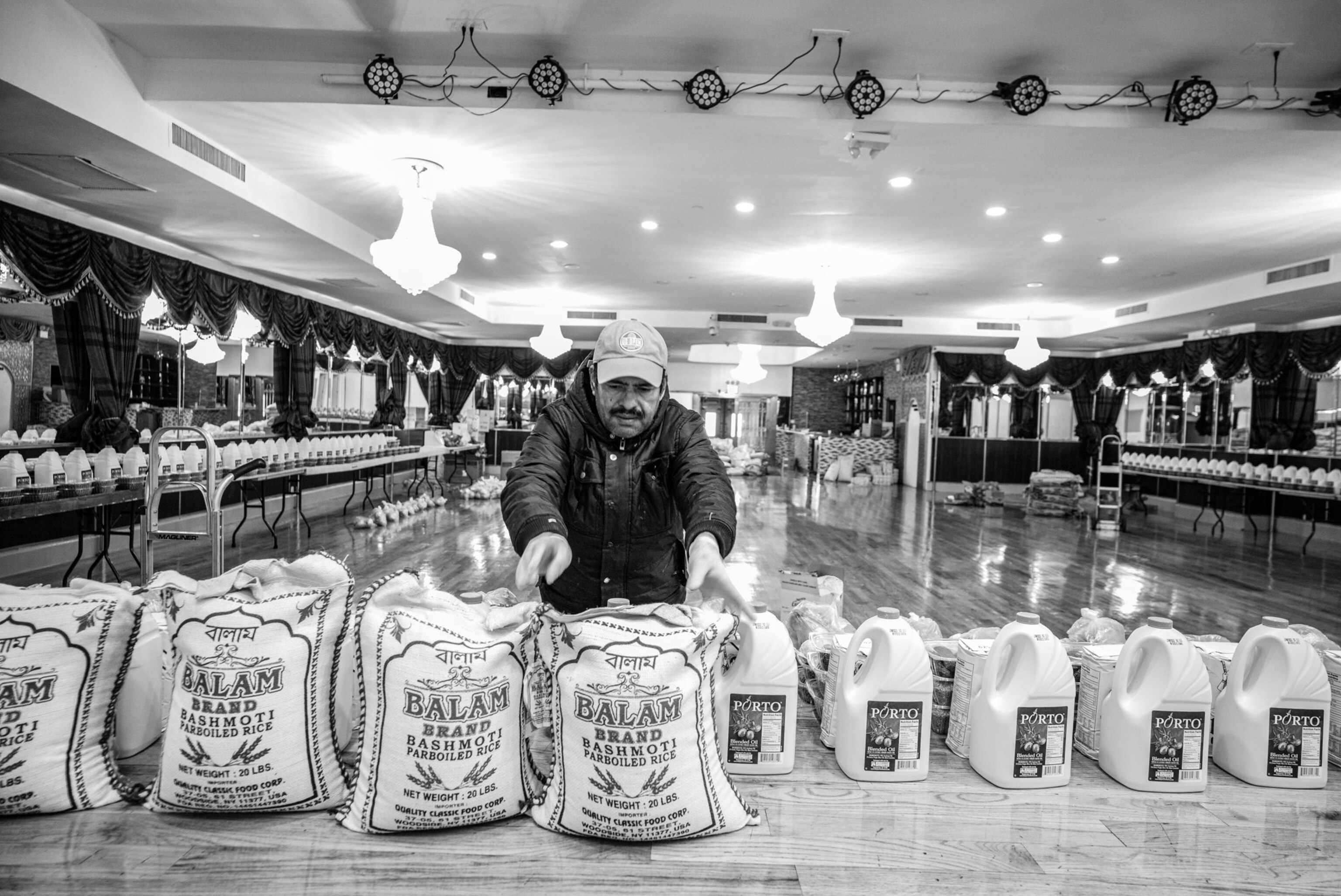 a person moving a bag of rice on a table of food donations