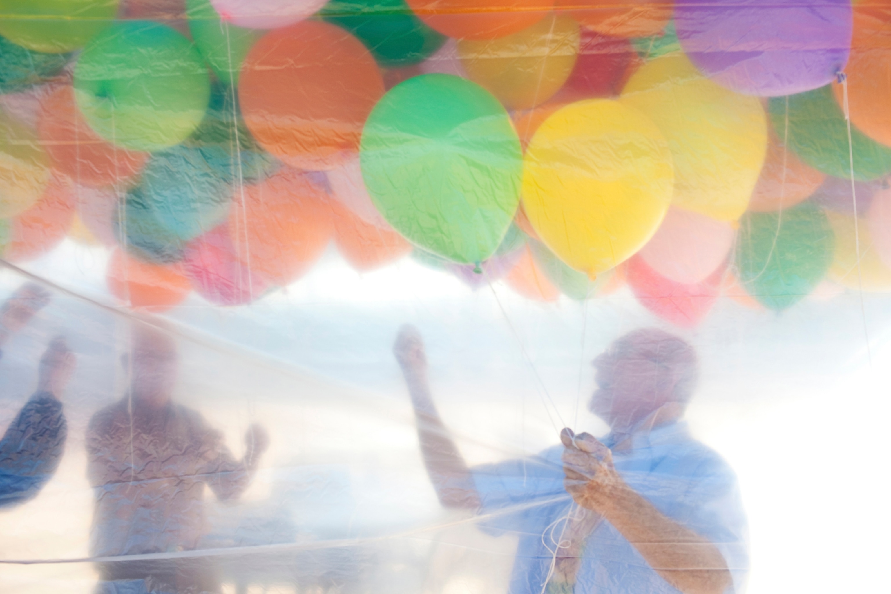 Photo of man with colorful balloons above him