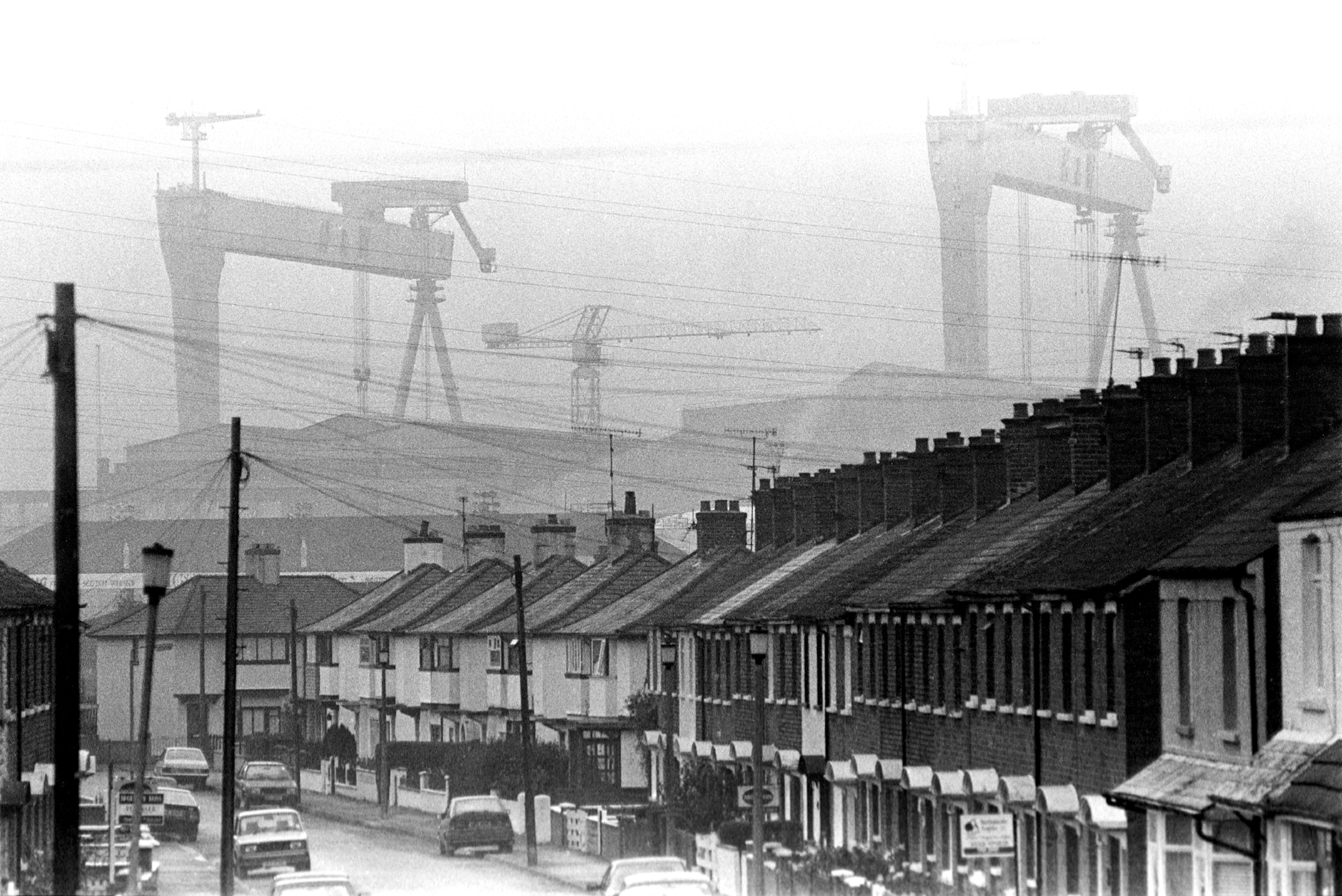 Shipping cranes tower over a neighborhood in Belfast