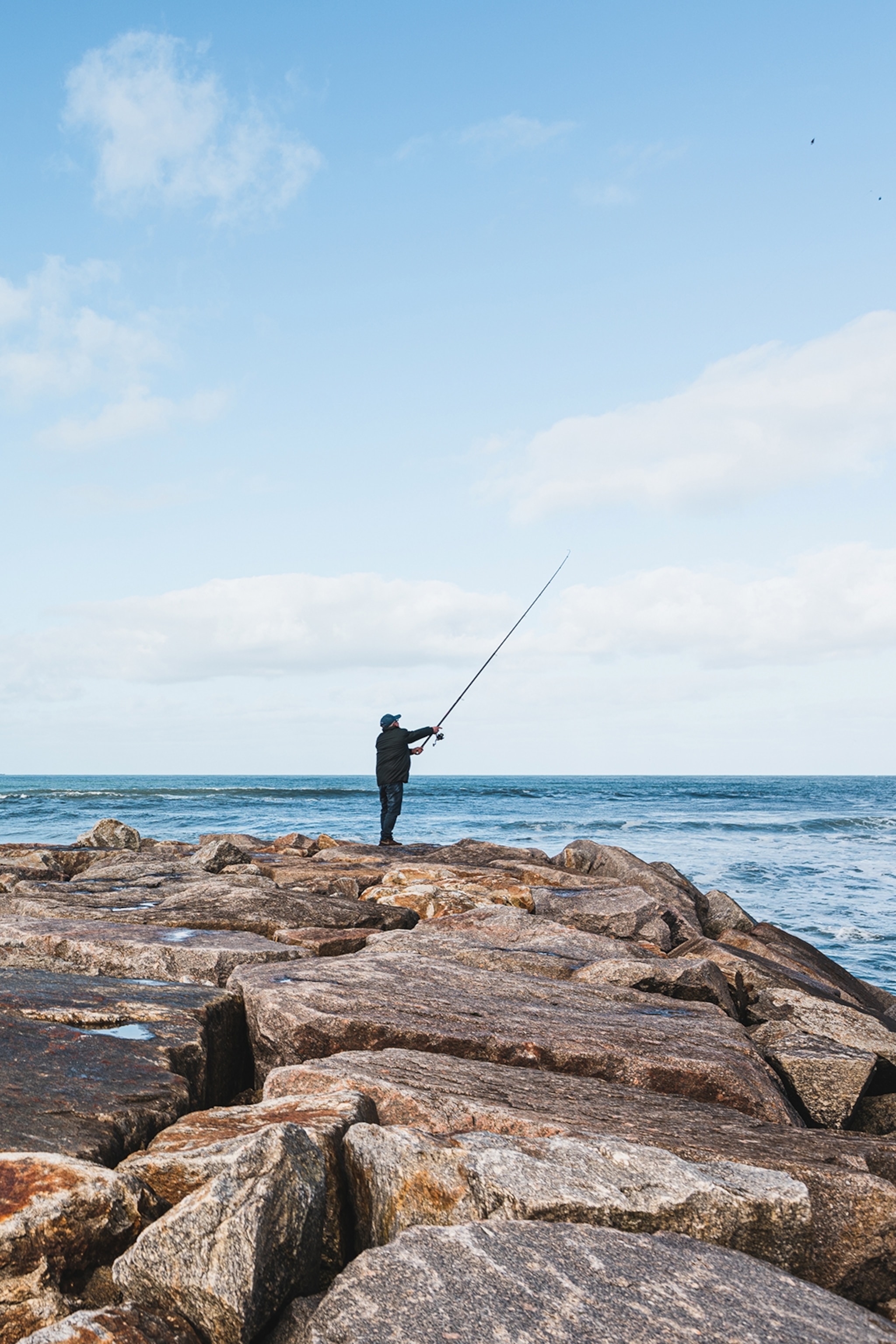 A man fishing on the rocks