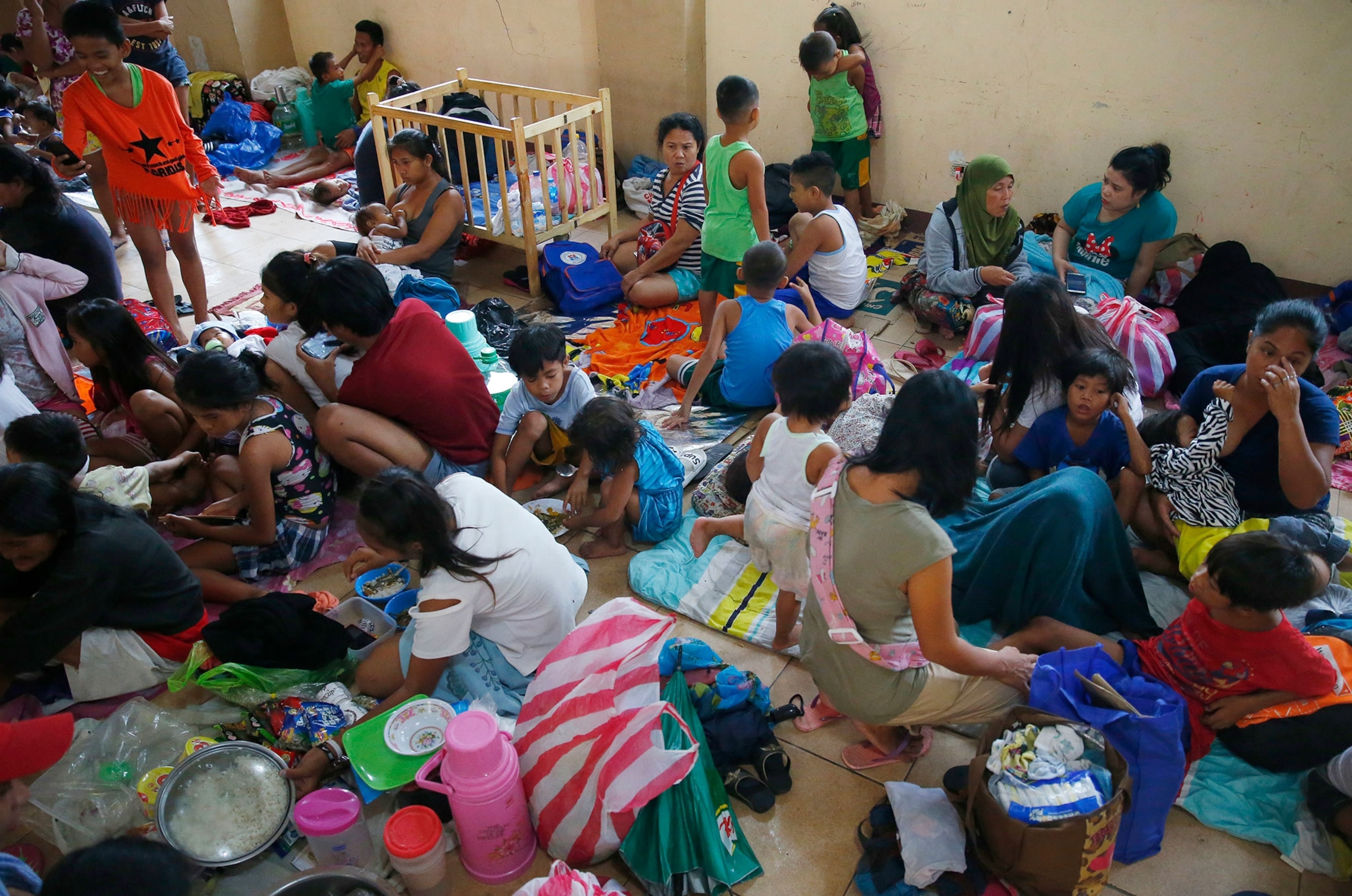 eesidents living along the coastal community of Baseco seek temporary shelter.