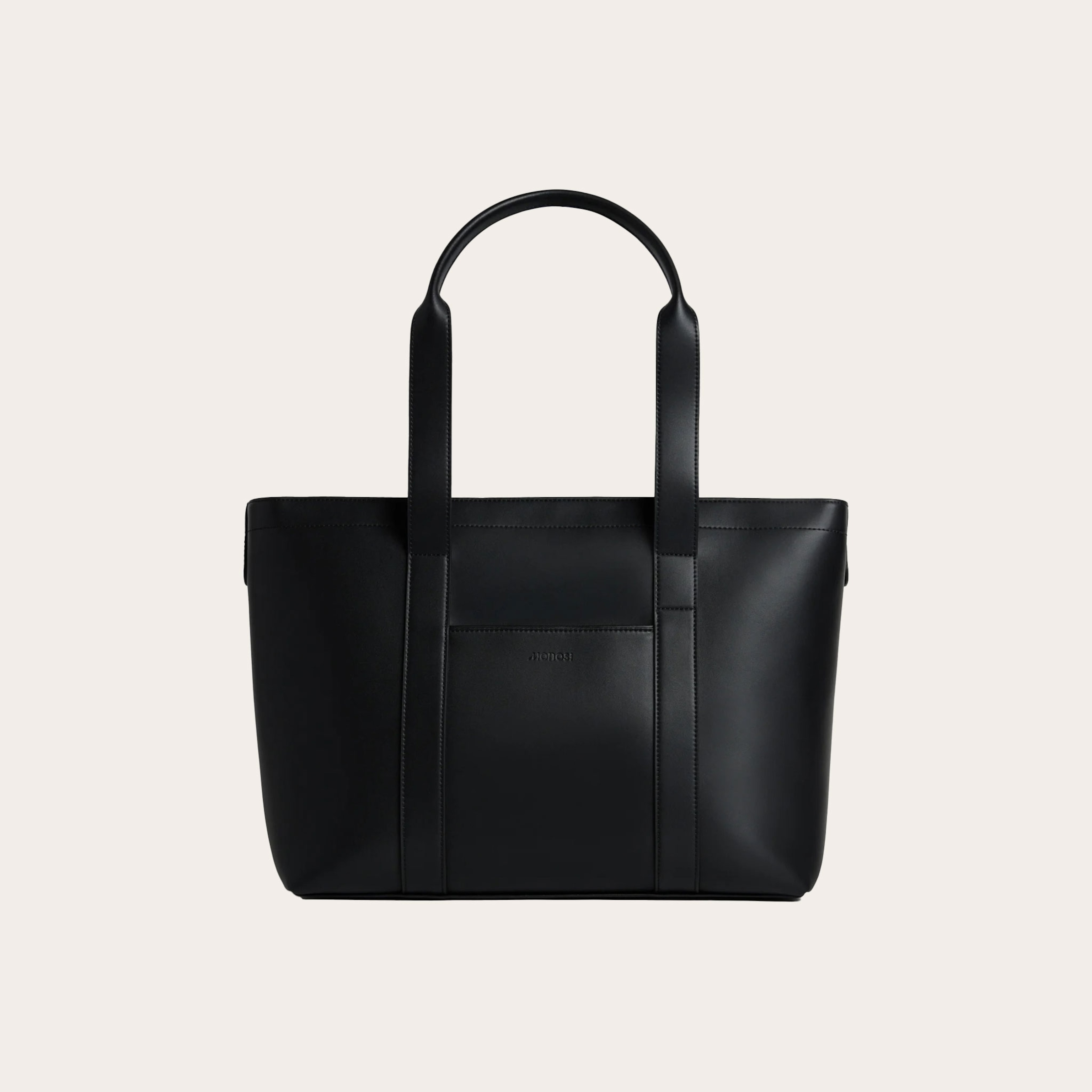 Black tote bag placed on a tan background.