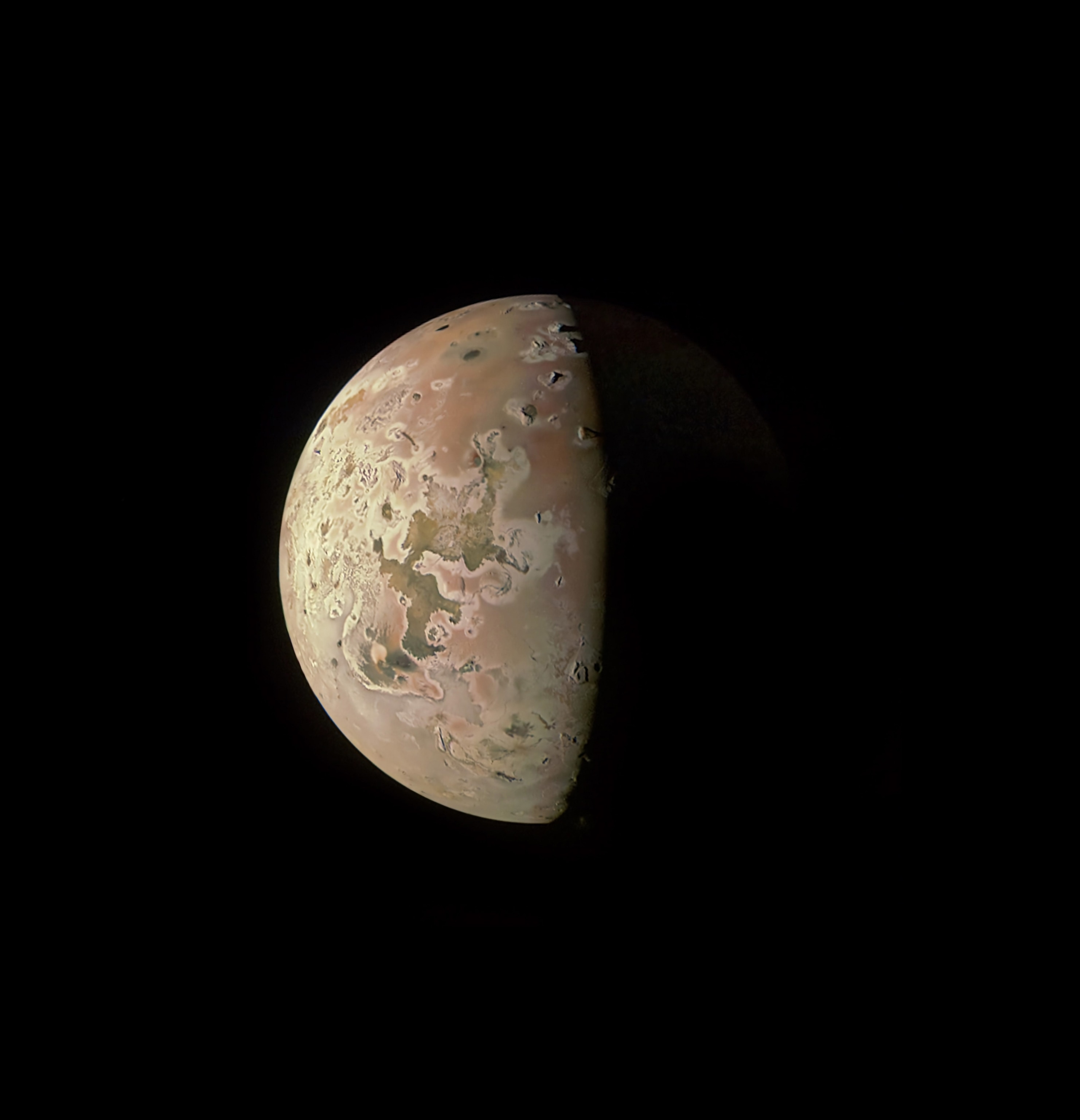 Jupiter's moon, Io, half in light and half in darkness, its surface marred by centuries of volcanic activity.