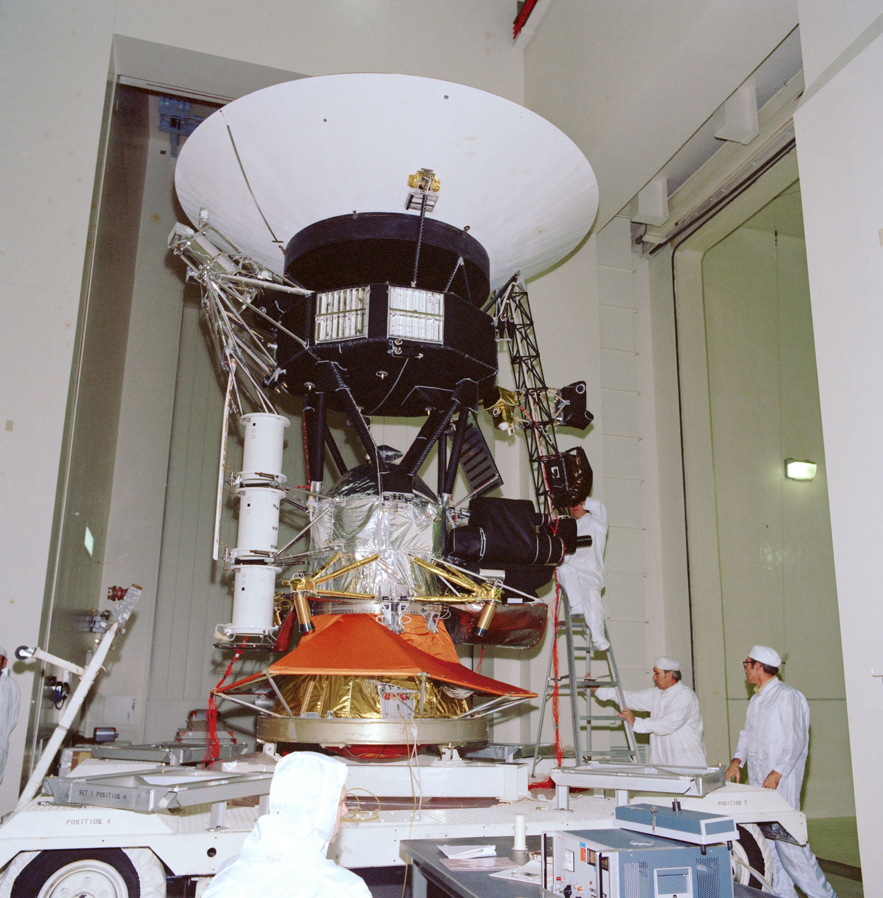 a voyager spacecraft being worked on by employees at NASA