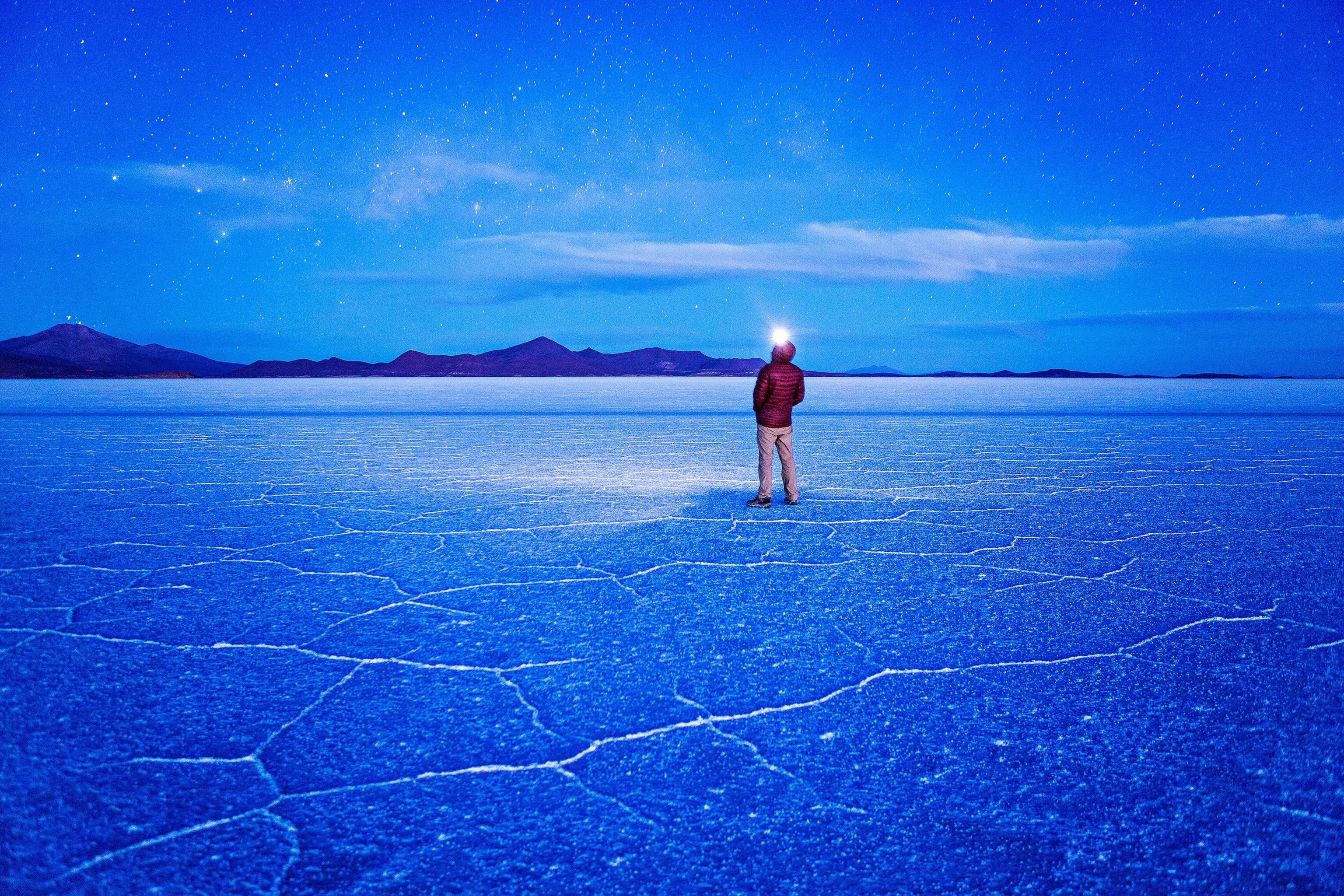 a traveler standing under the night sky at Salar de Uyuni, Bolivia