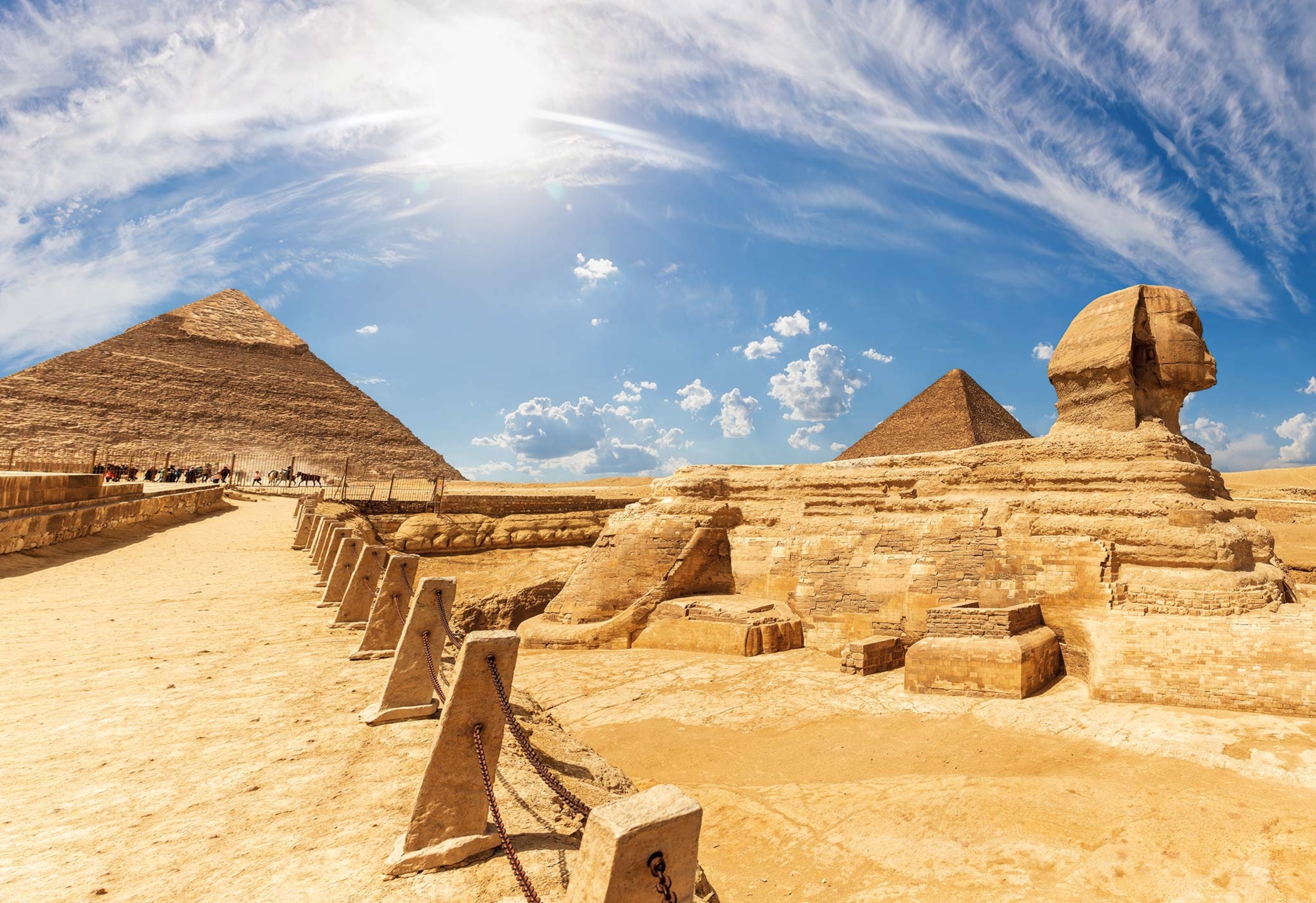 Modern visitors to the Giza plateau gaze on a Sphinx free of sand, following clearance work carried out in the 1930s. Behind rises the Great Pyramid of Khufu, the tallest of Giza’s structures, topping out at 450 feet.