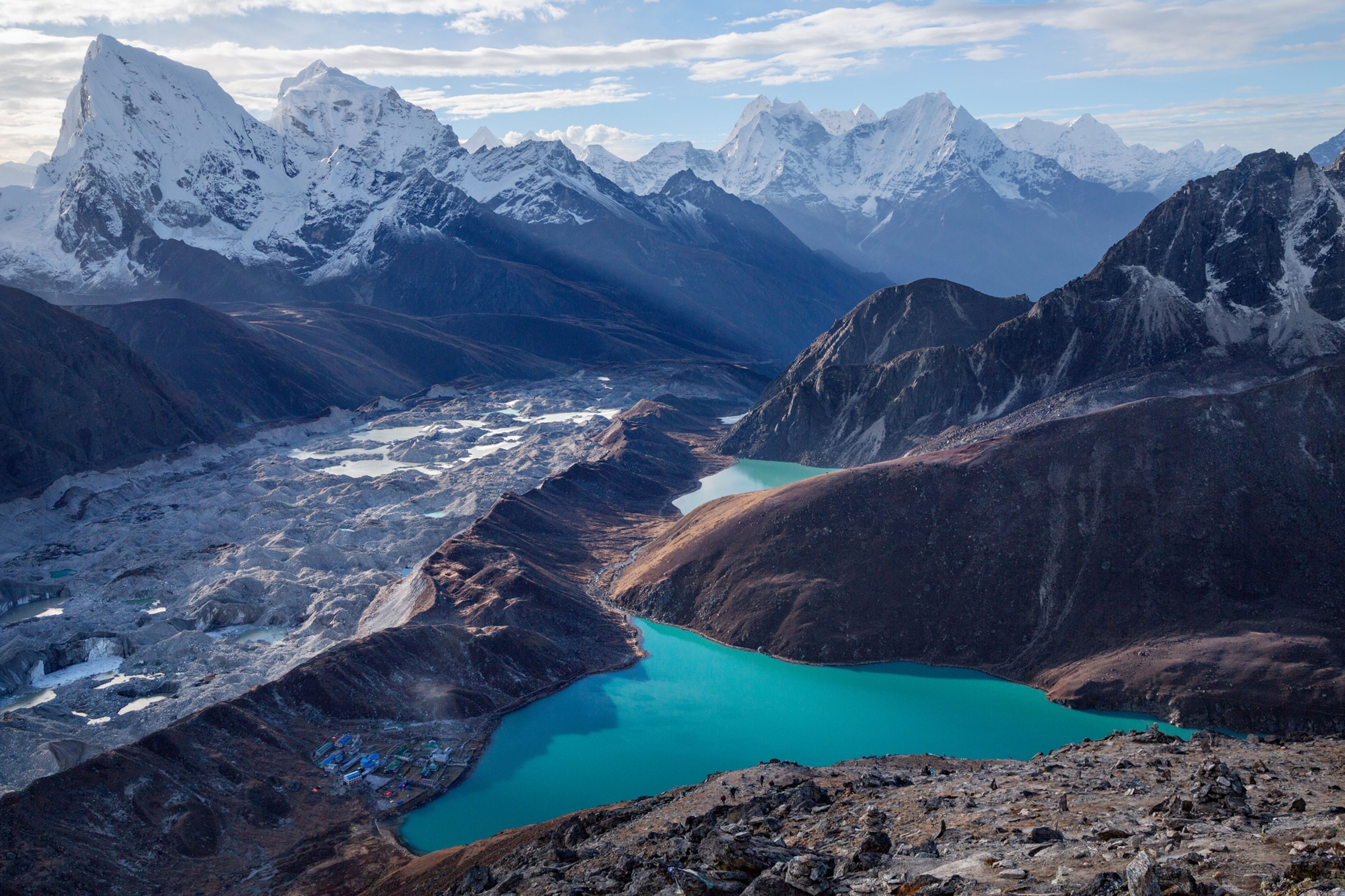 blue lake surrounded by mountains with snow-covered tops.