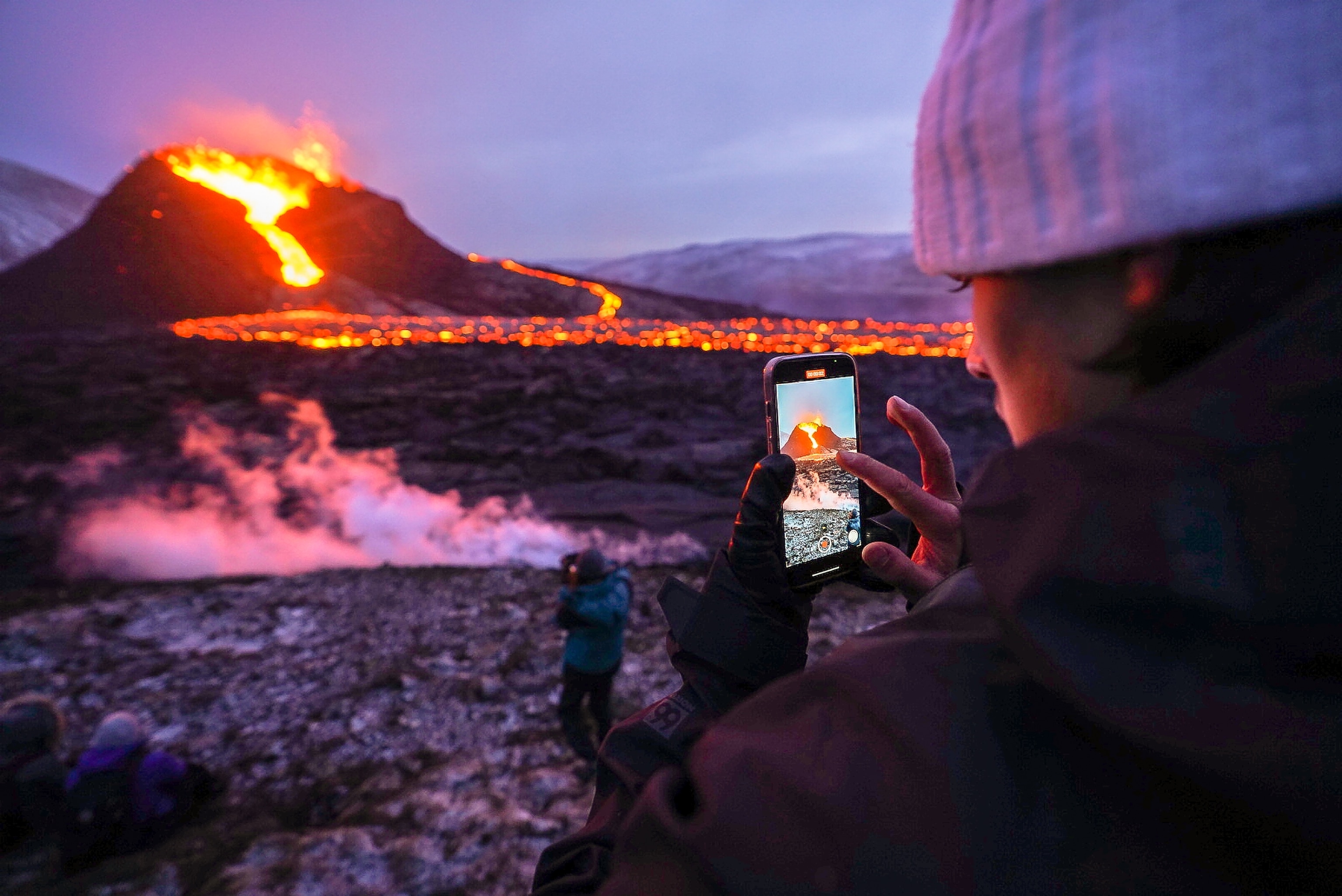 crowds of tourists walking around the flow of the erupted volcano