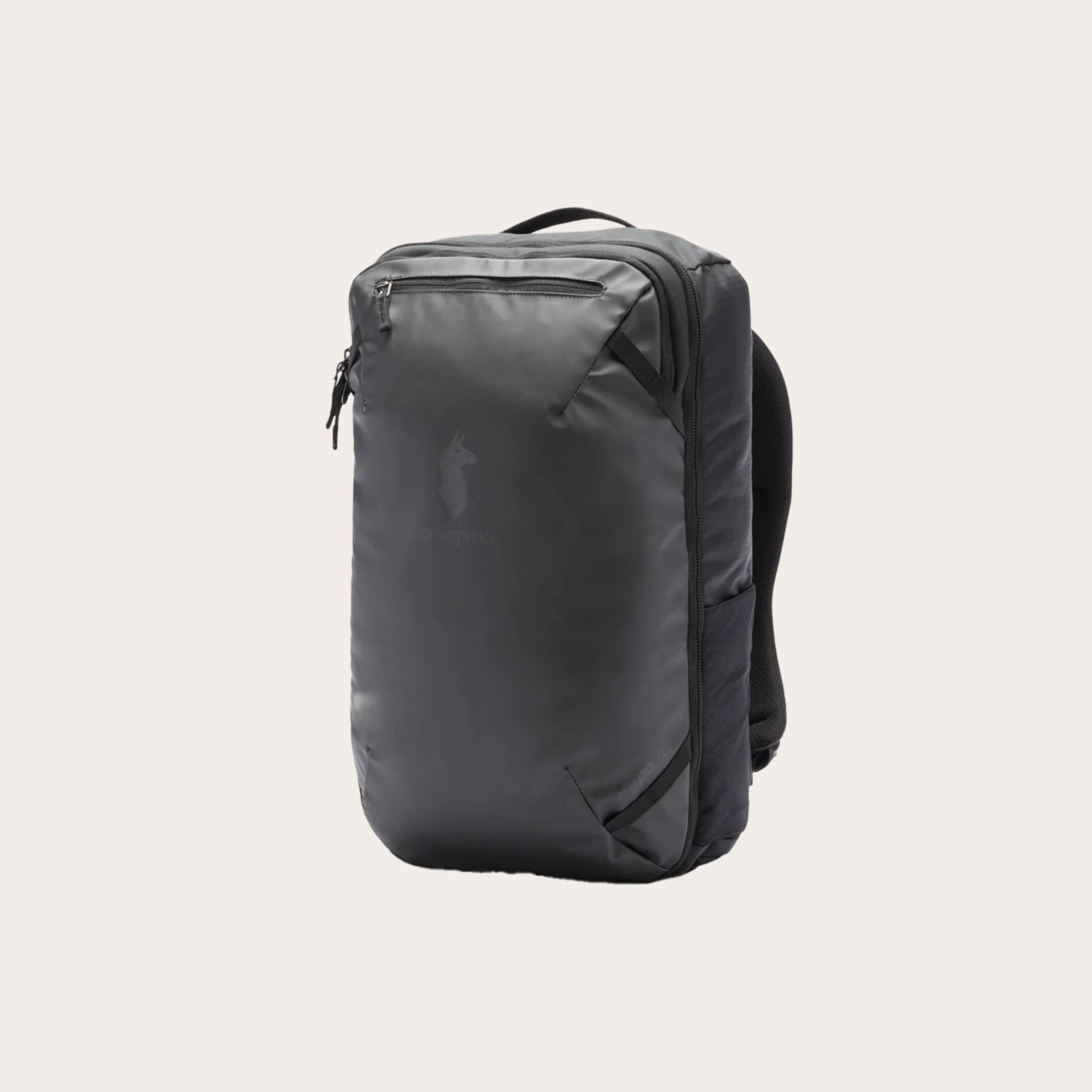 Black backpack placed in front of a tan background.