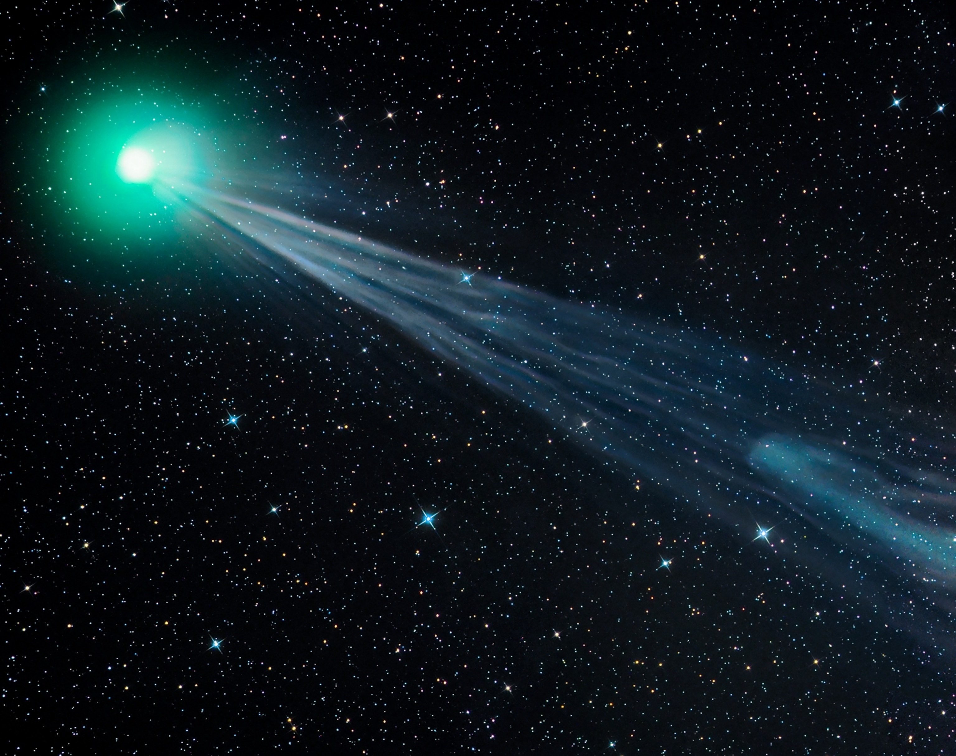 Picture of the comet's coma tinted green by gas fluorescing in sunlight.