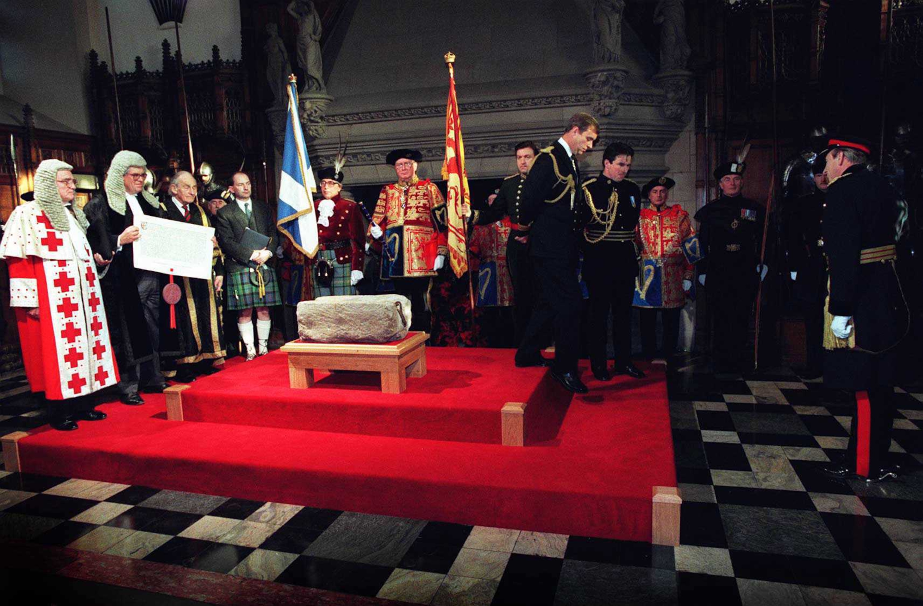 Photo of stone on red carpet with royalty around it