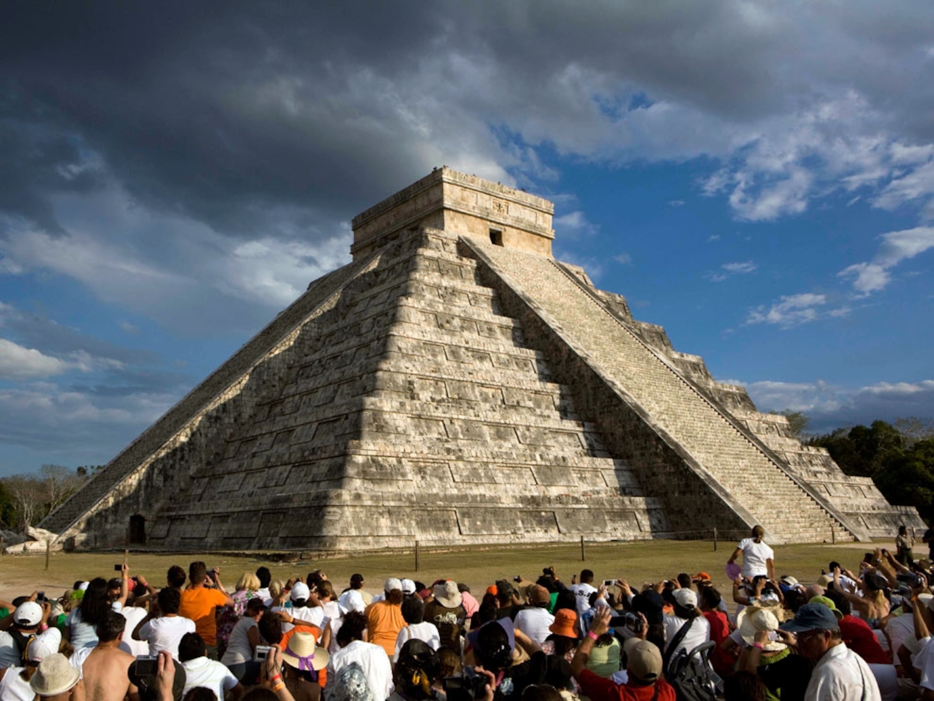 People sitting around Maya pyramid