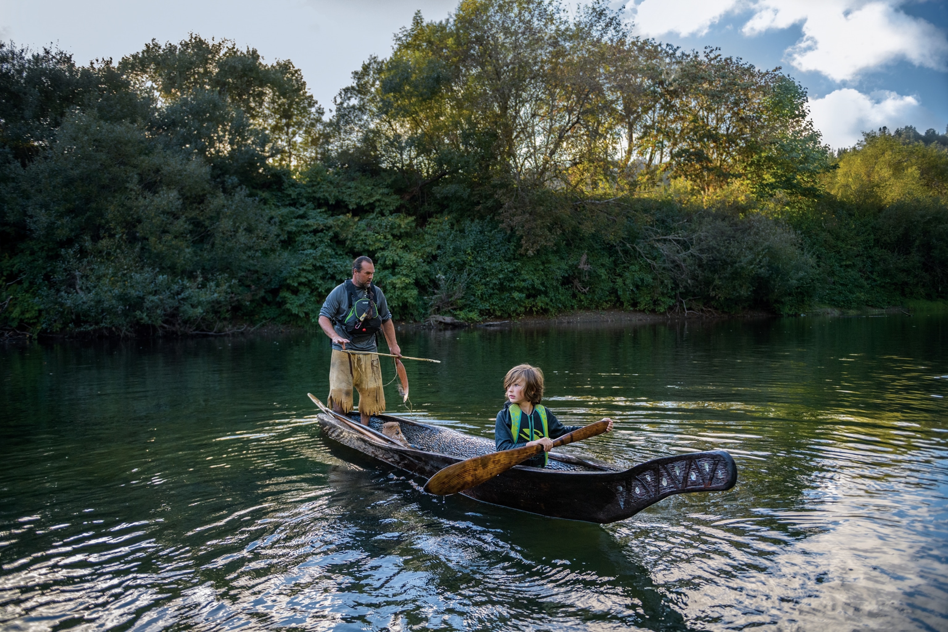 Picture of Justin Futch and his son, Zade, in a carved wooden canoe.