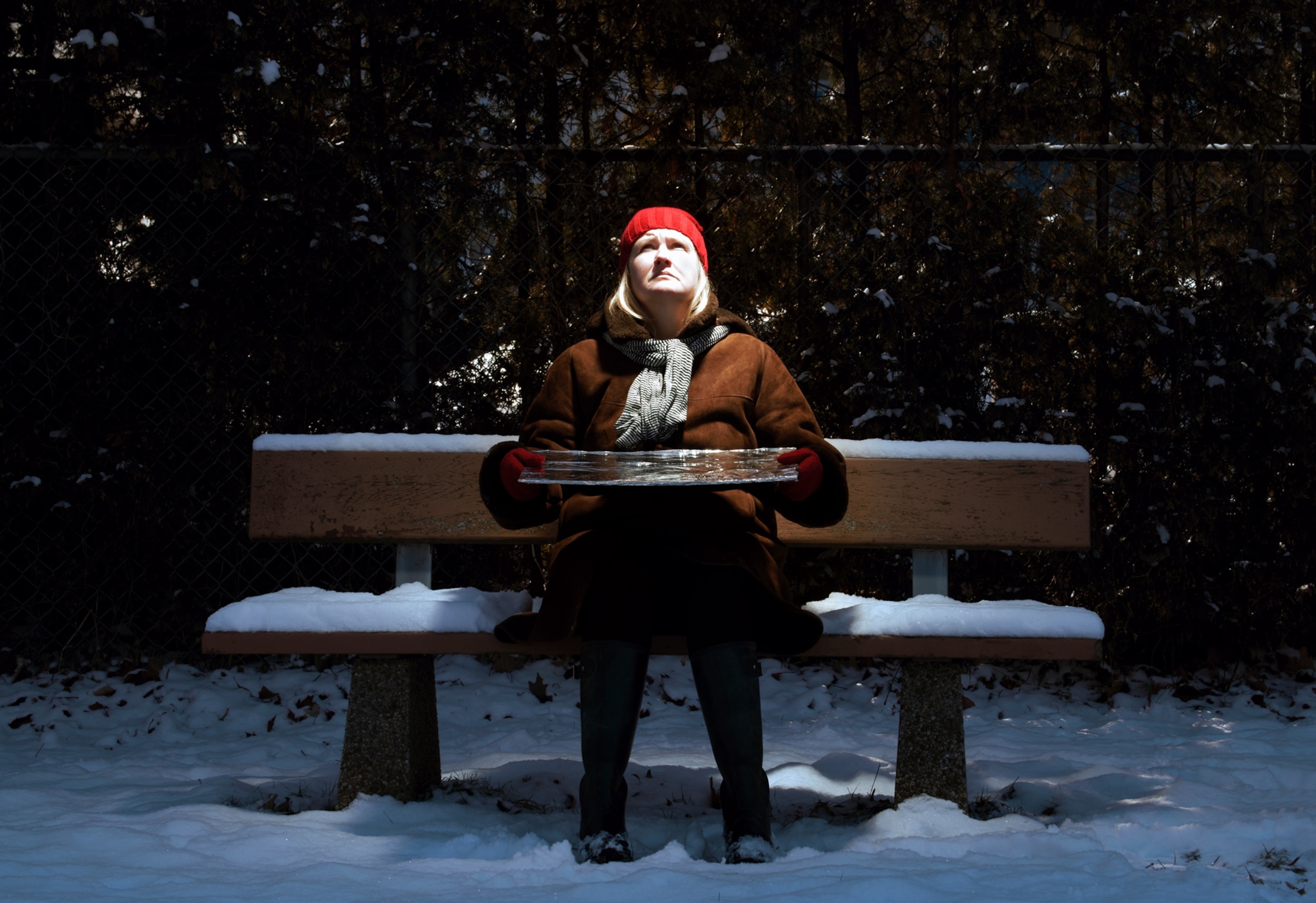 Photo of woman on bench with reflected light on her face