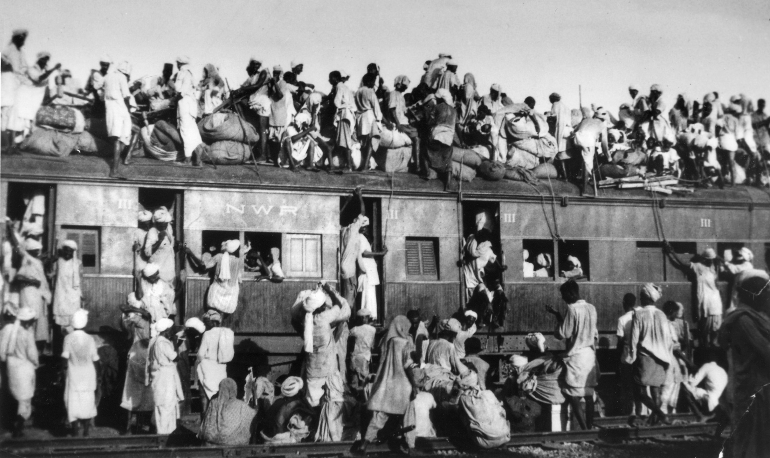 black and white photograph of train overflowing with people
