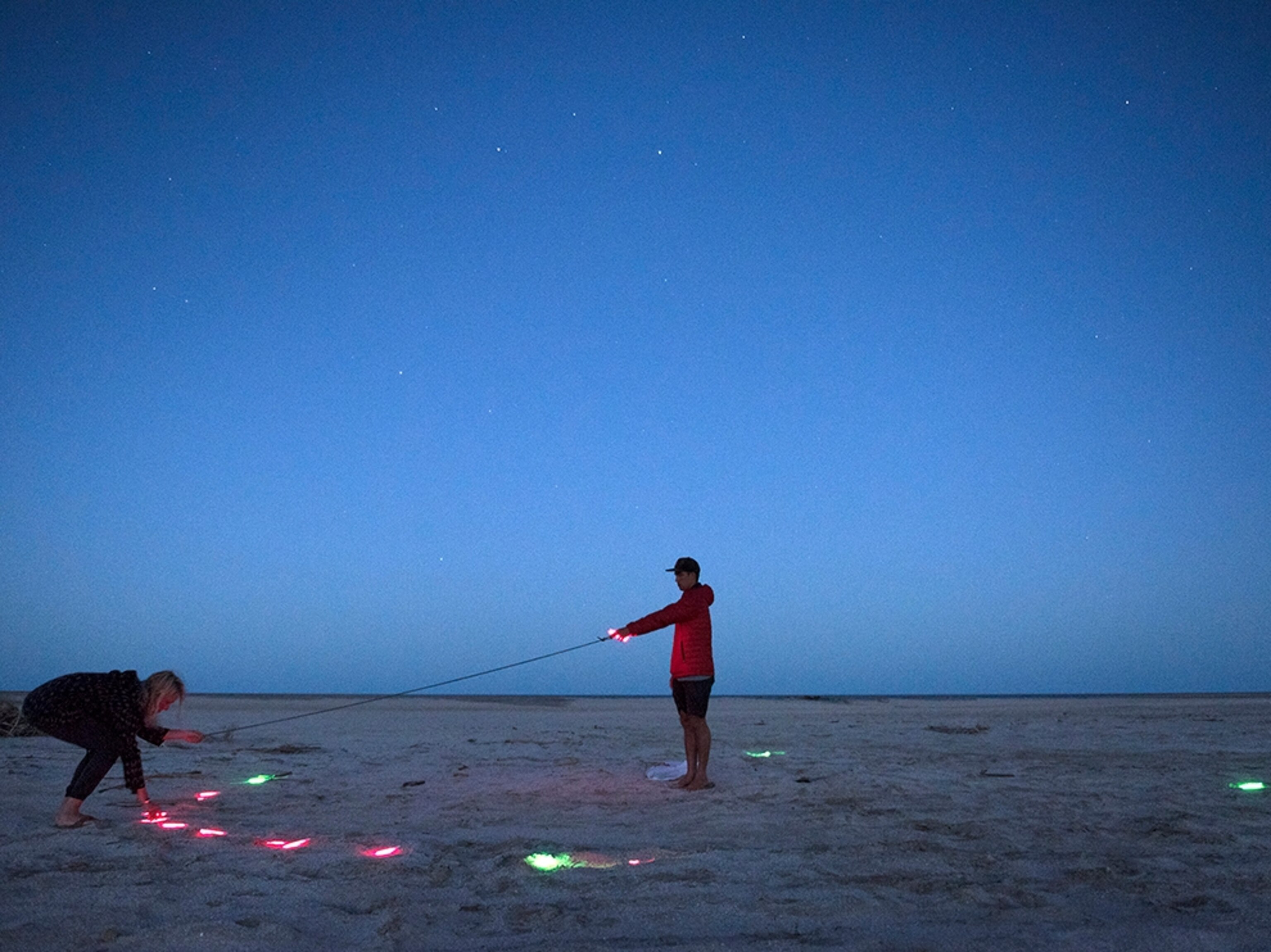 a man setting up a star compass on the beach at night in Baja, Mexico