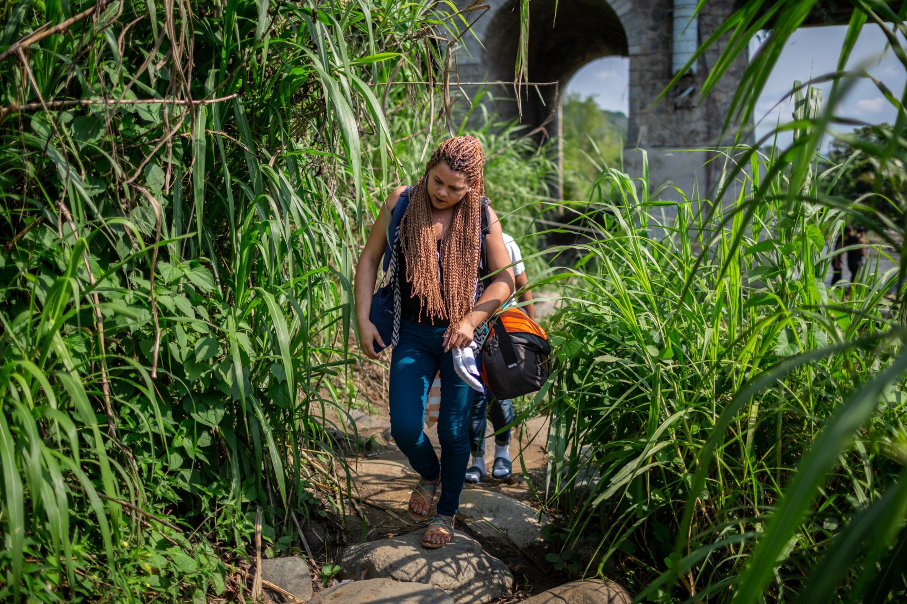 a woman walking through tall grasses