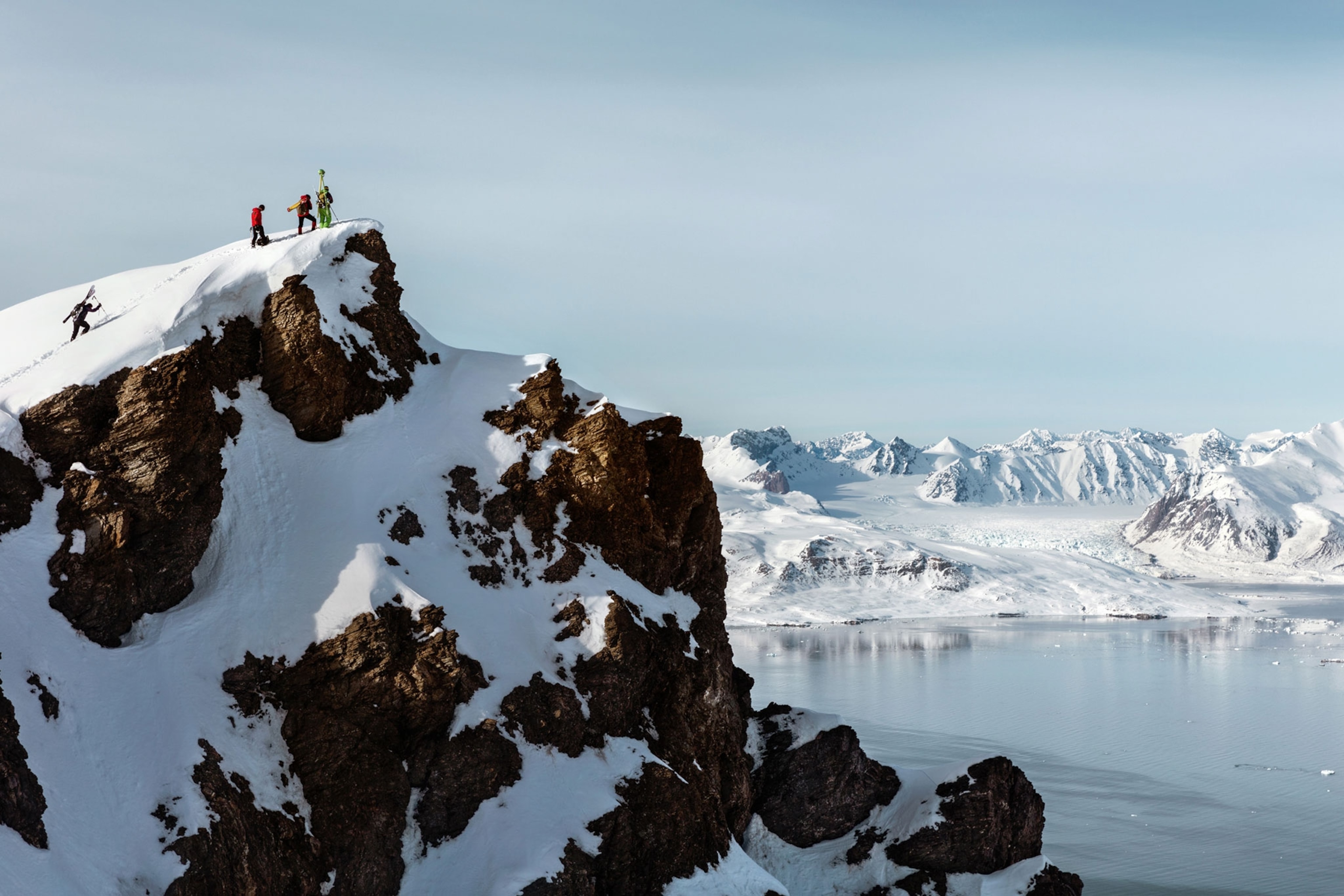 glaciologists on a ridge overlooking a glacier they are about to monitor.