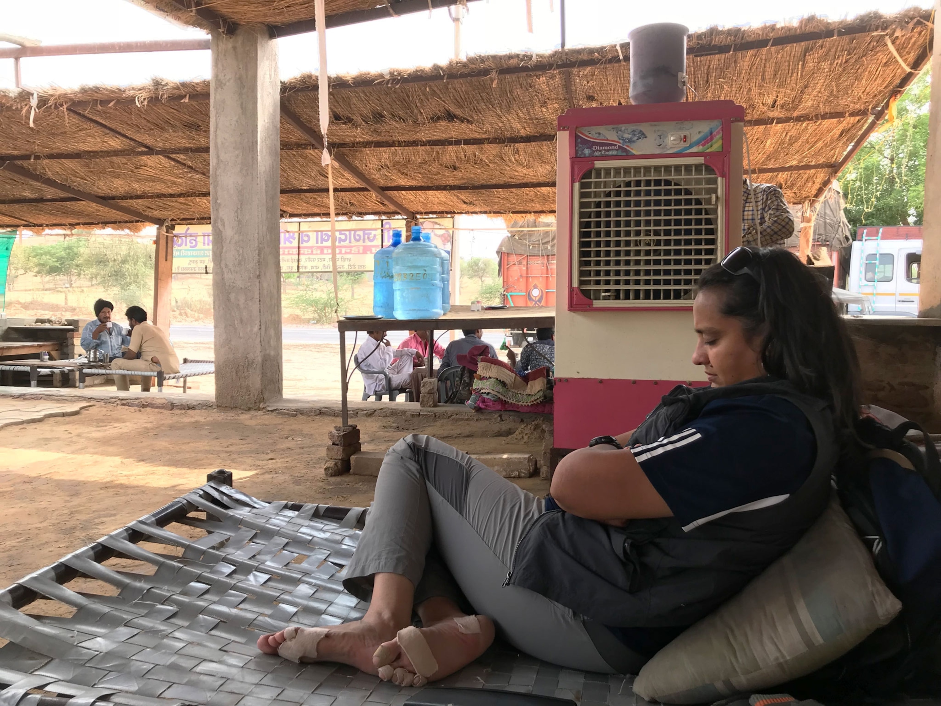 a woman resting in the shade her feet wrapped in bandages