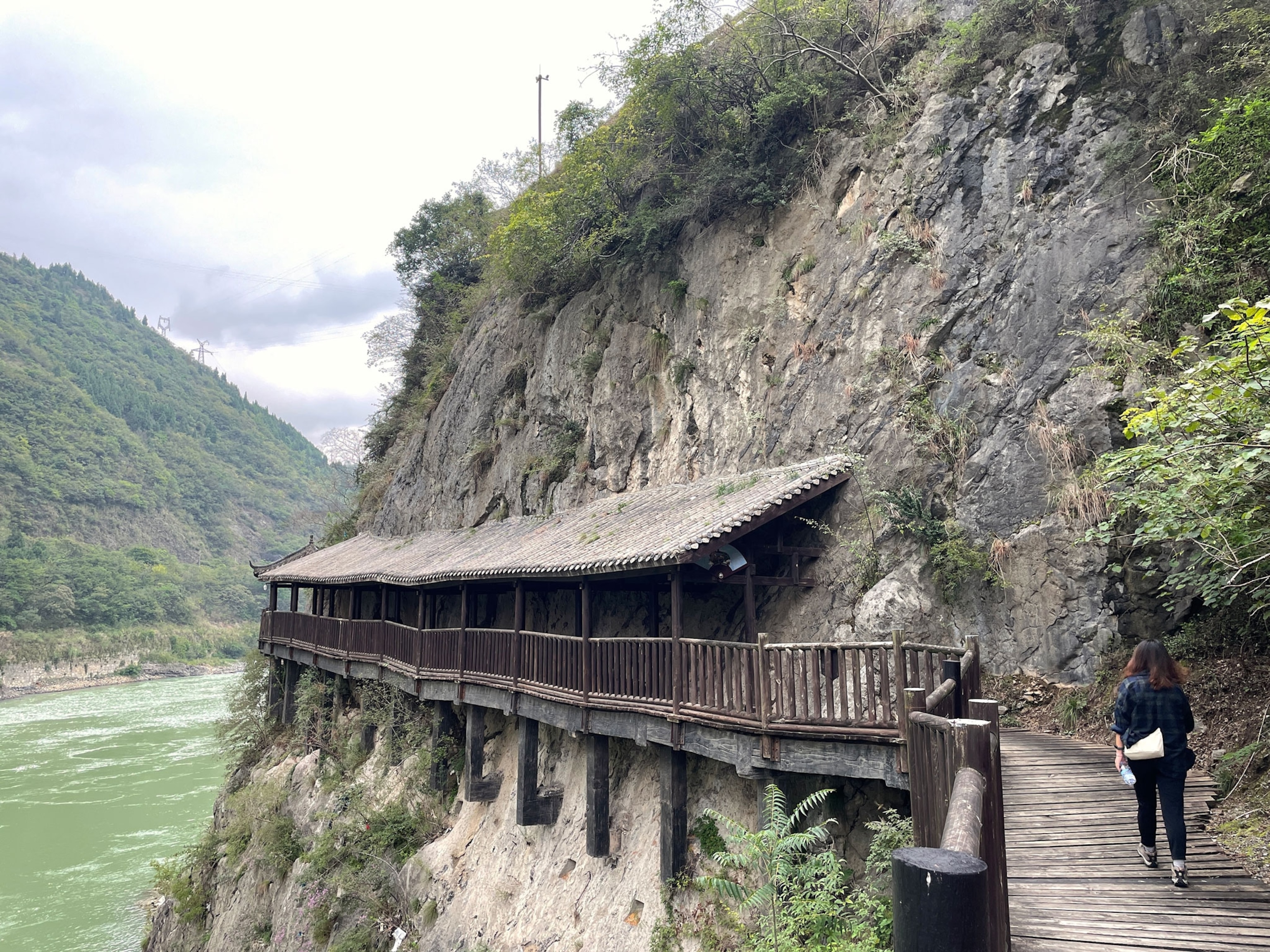 Photo of wooden plank pathway along mountainside and river