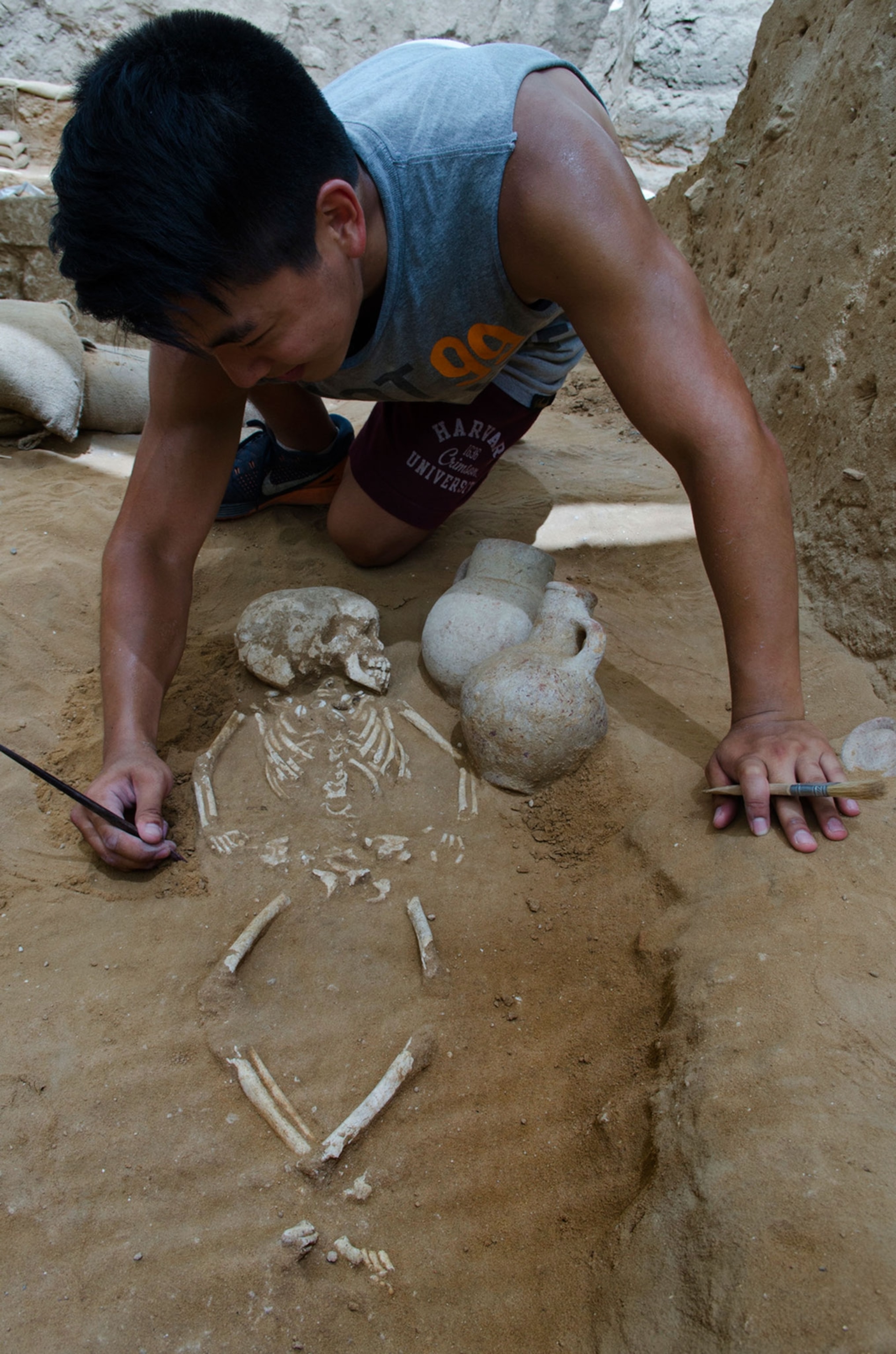 archaeologist excavating child grave in Philistine cemetery in Ashkelon, Israel