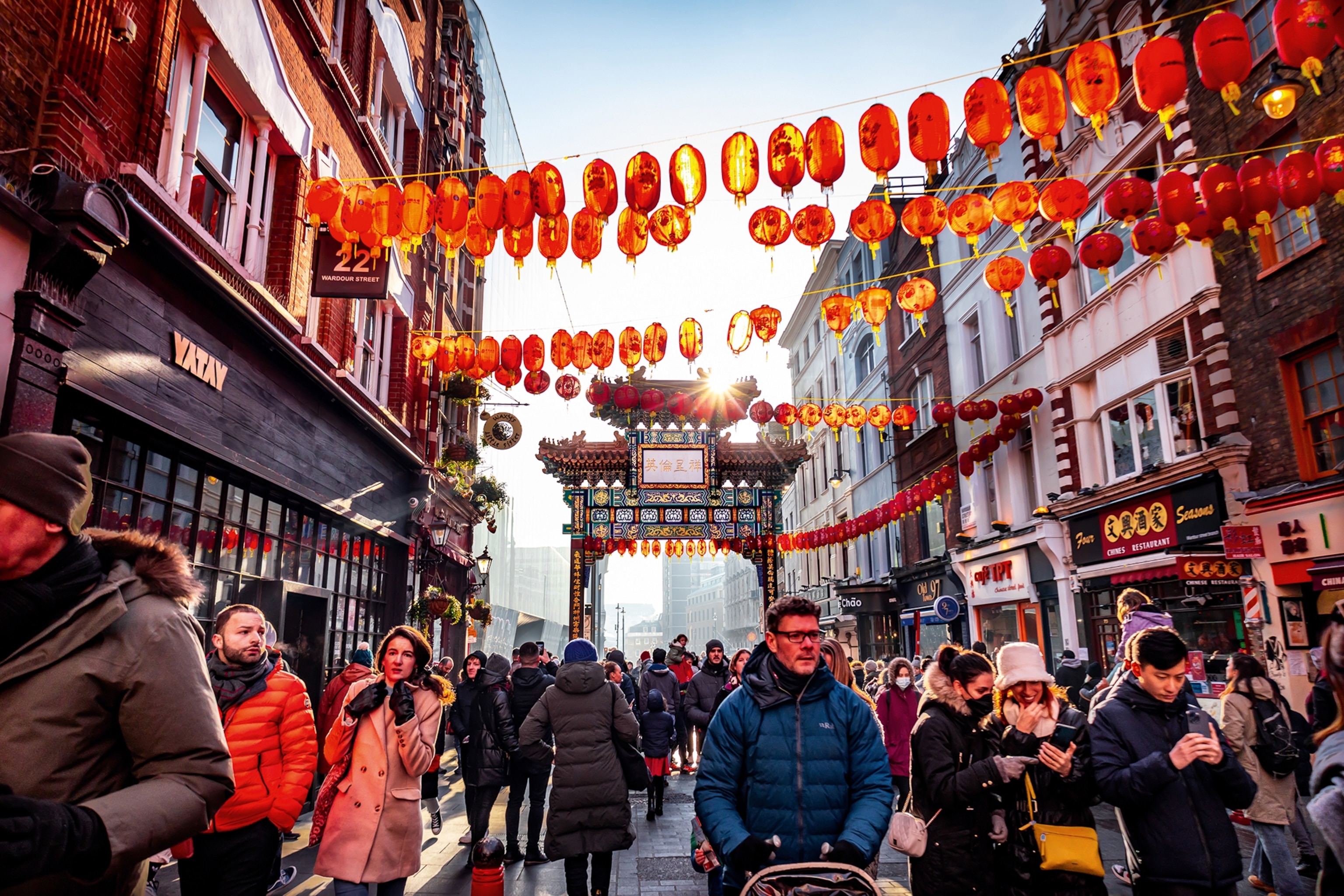 Patrons in London's Chinatown during the Chinese new year festival. Red lanterns are hung above the street.