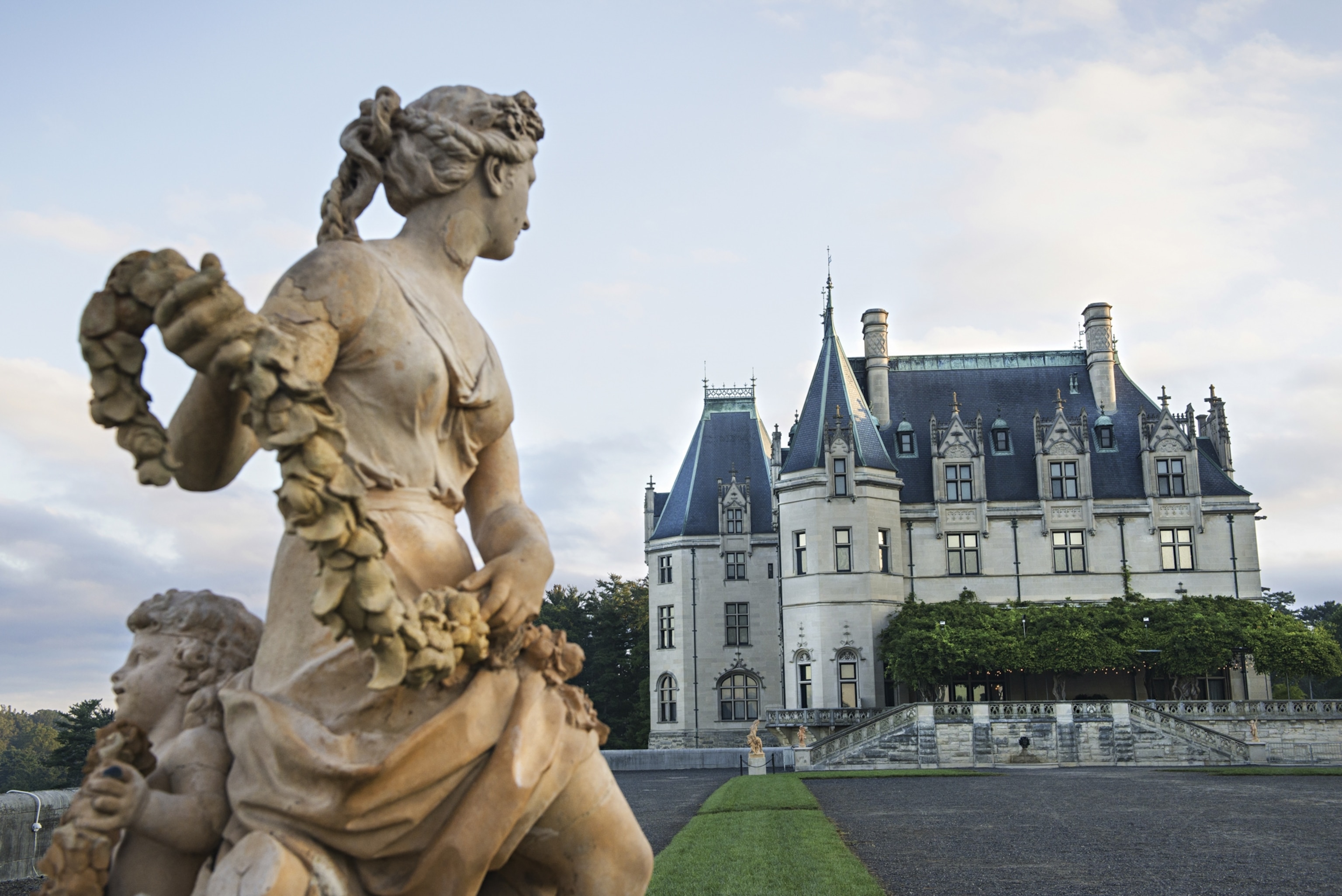 A marble statue standing before a mansion.