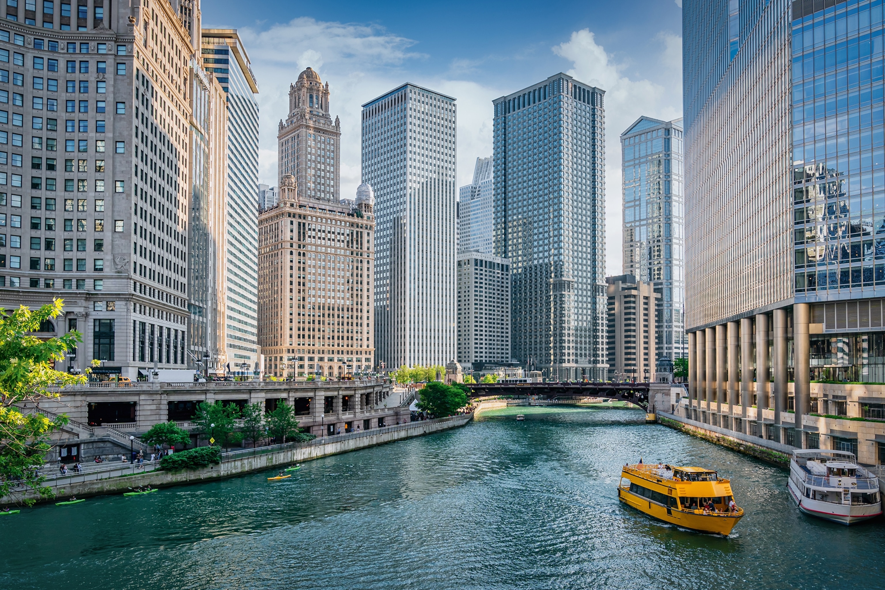 A view on a wide river running through a city skyline with a boat in the foreground.