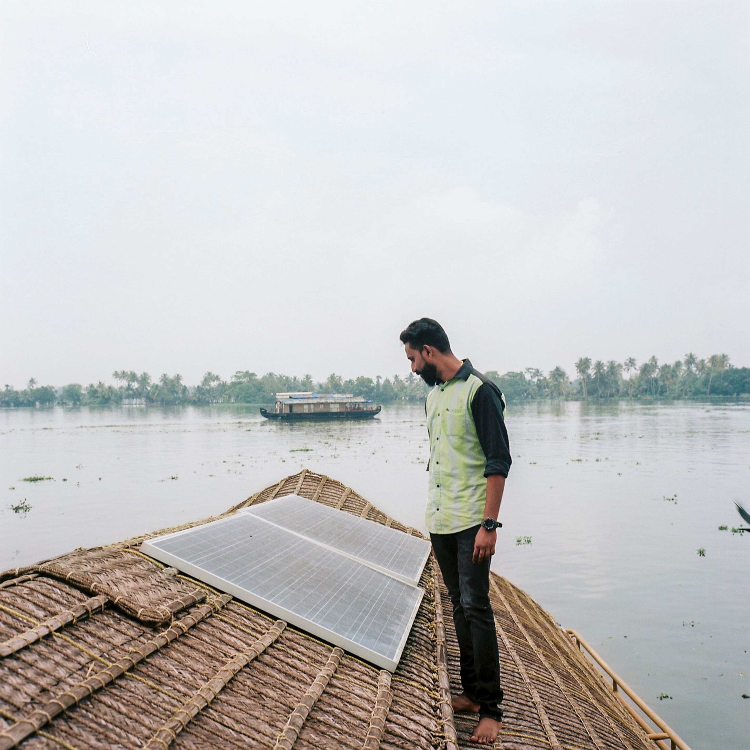 Vineeth Joseph, 31, a houseboat owner, with partial solar installation, stands for a portrait on his boat.