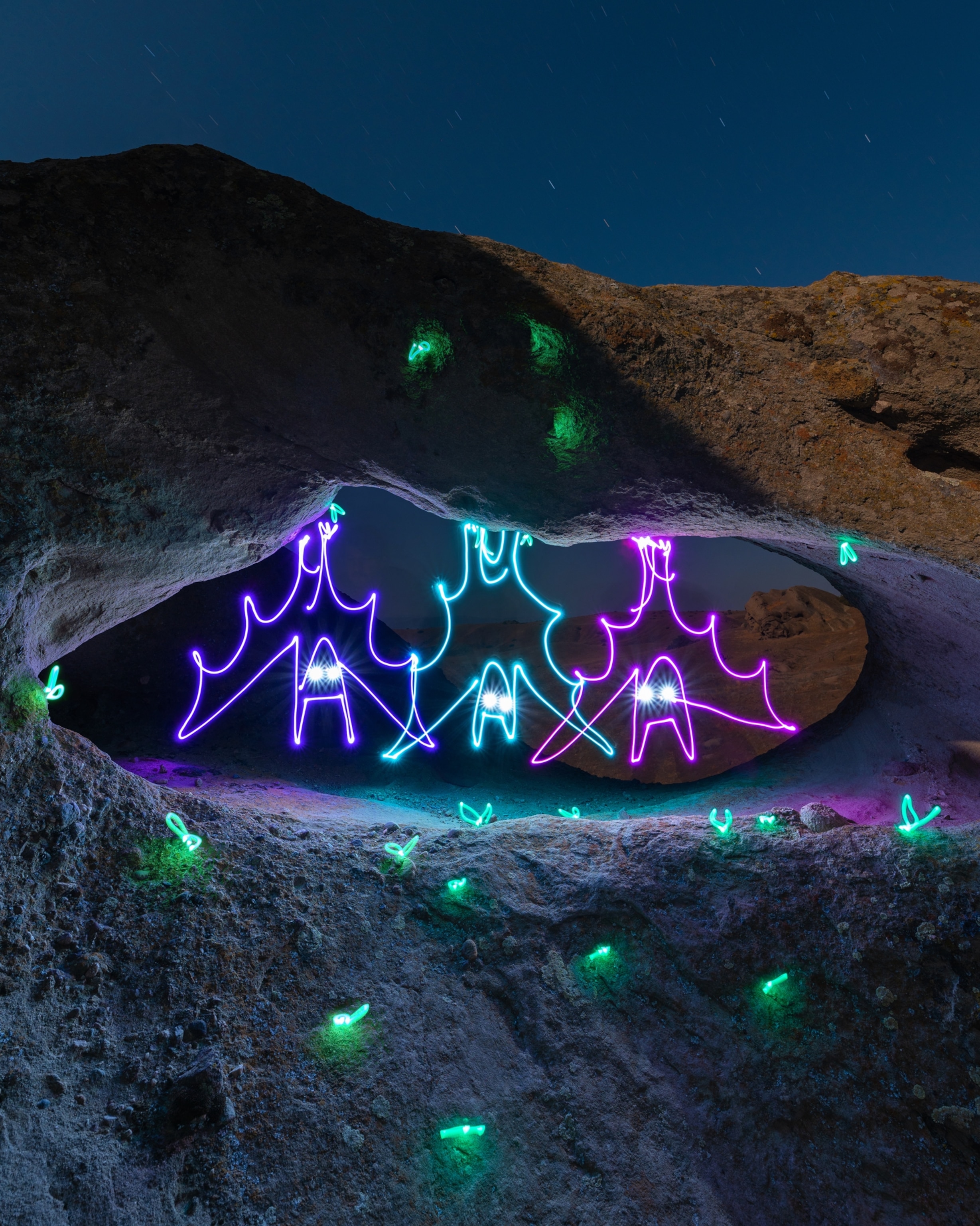 Picture of light painting of bats hanging in a cave.