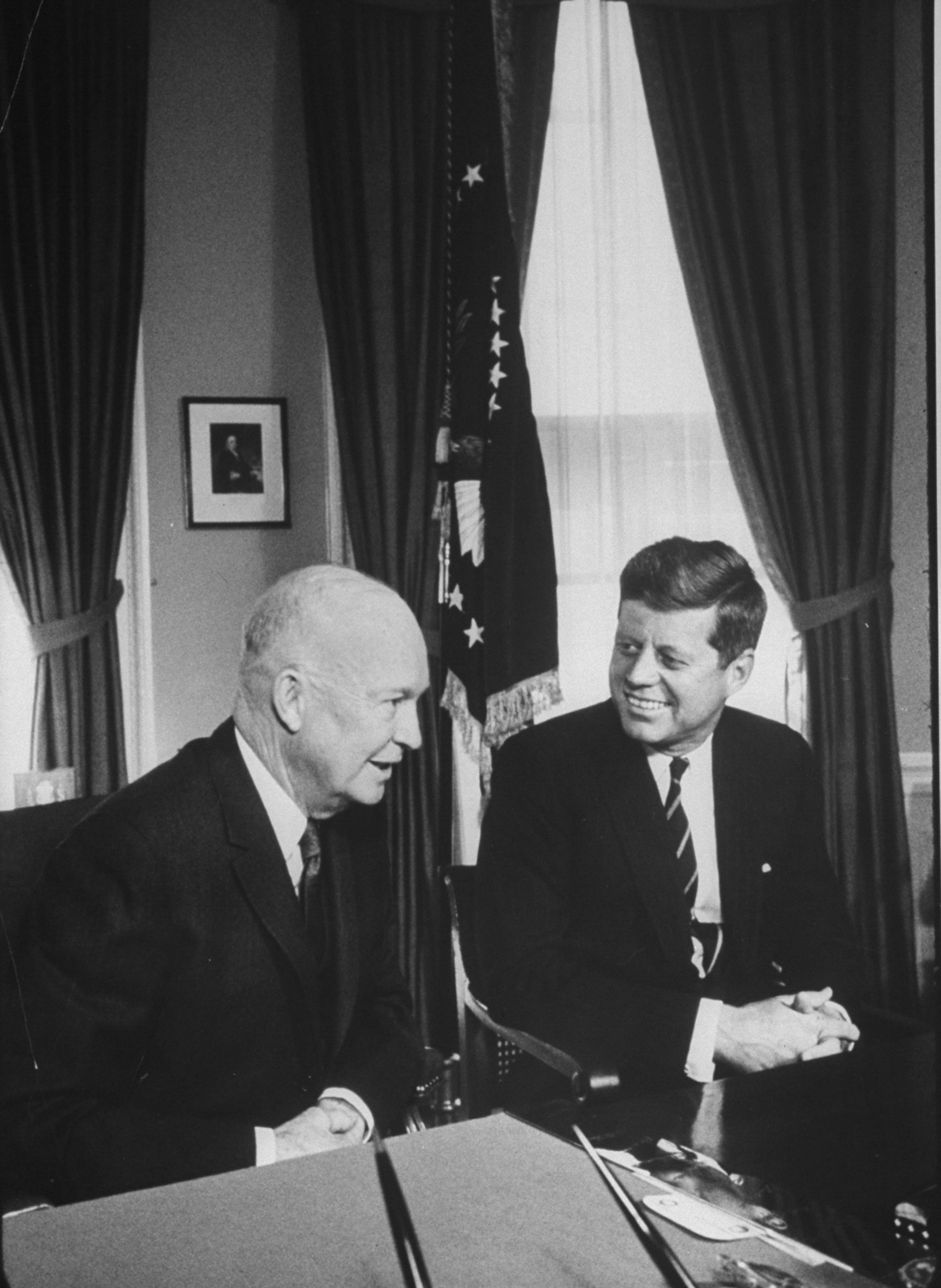 two former presidents sitting at a desk