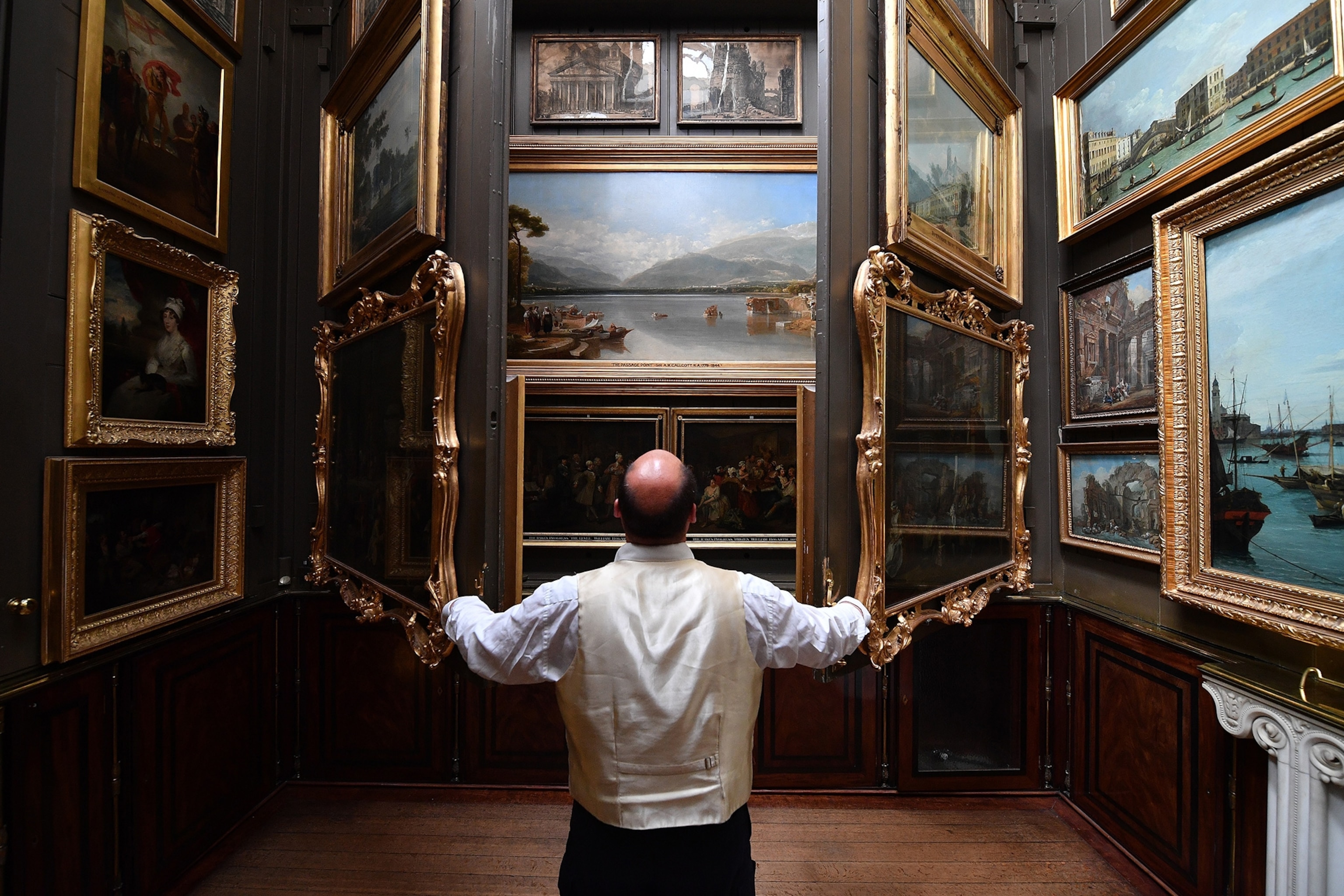 Visitor Assistant Jonty Stern poses in The Picture Room of The Sir John Soanes Museum in London.