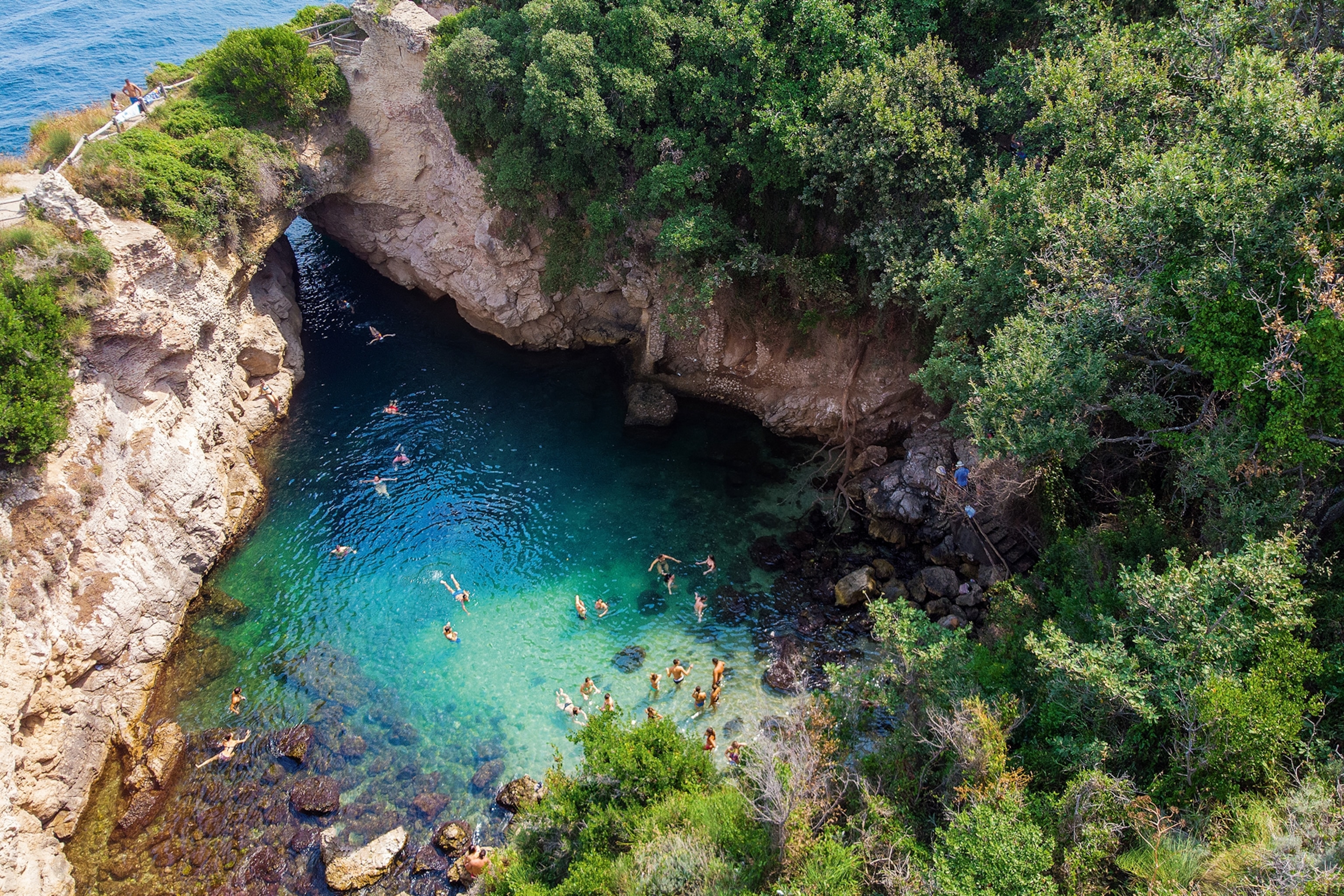 Swimmers swimming in a cove of sea water
