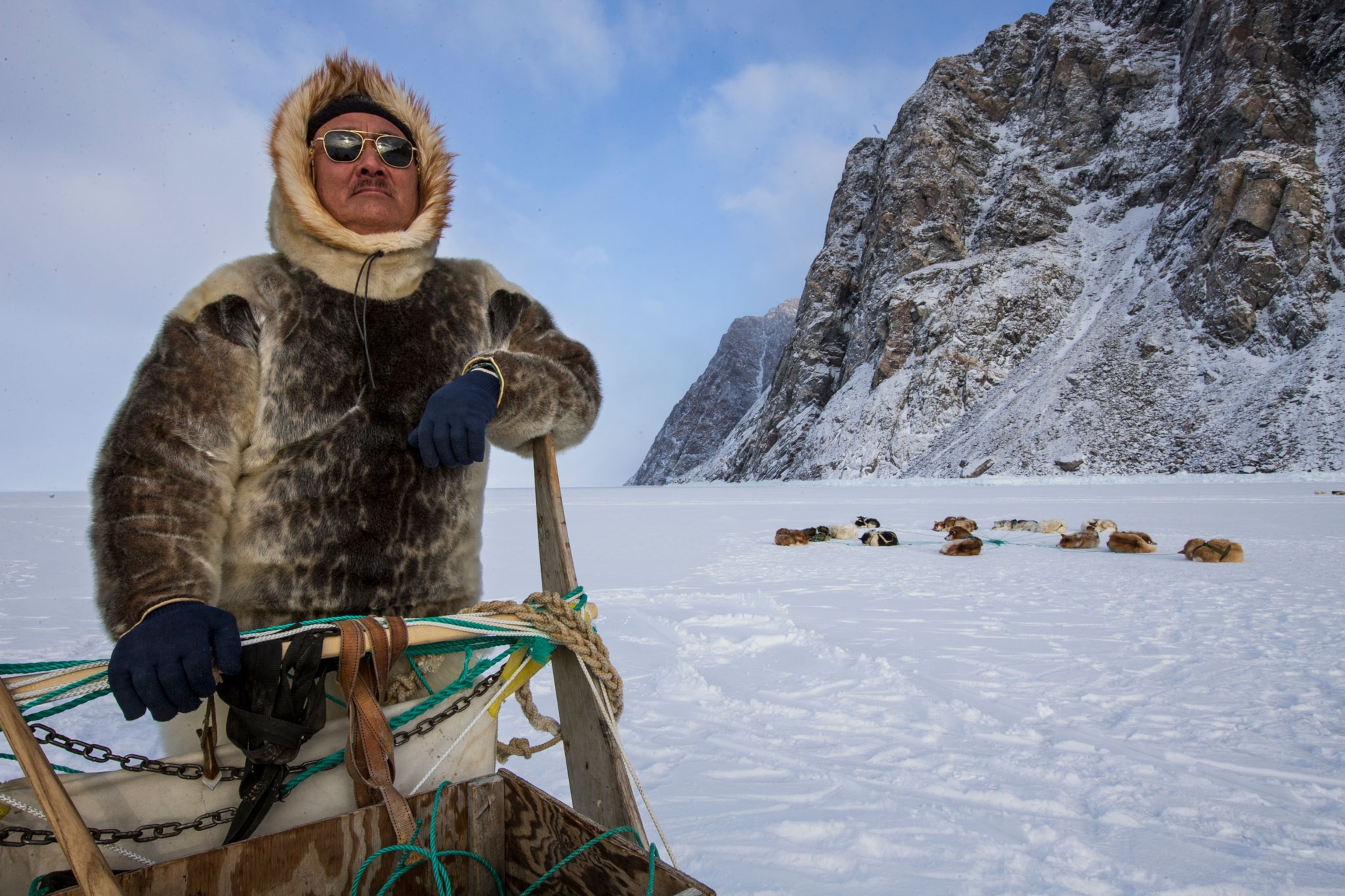 An Inuit hunter and a husky dog sled team on Greenland's sea ice.