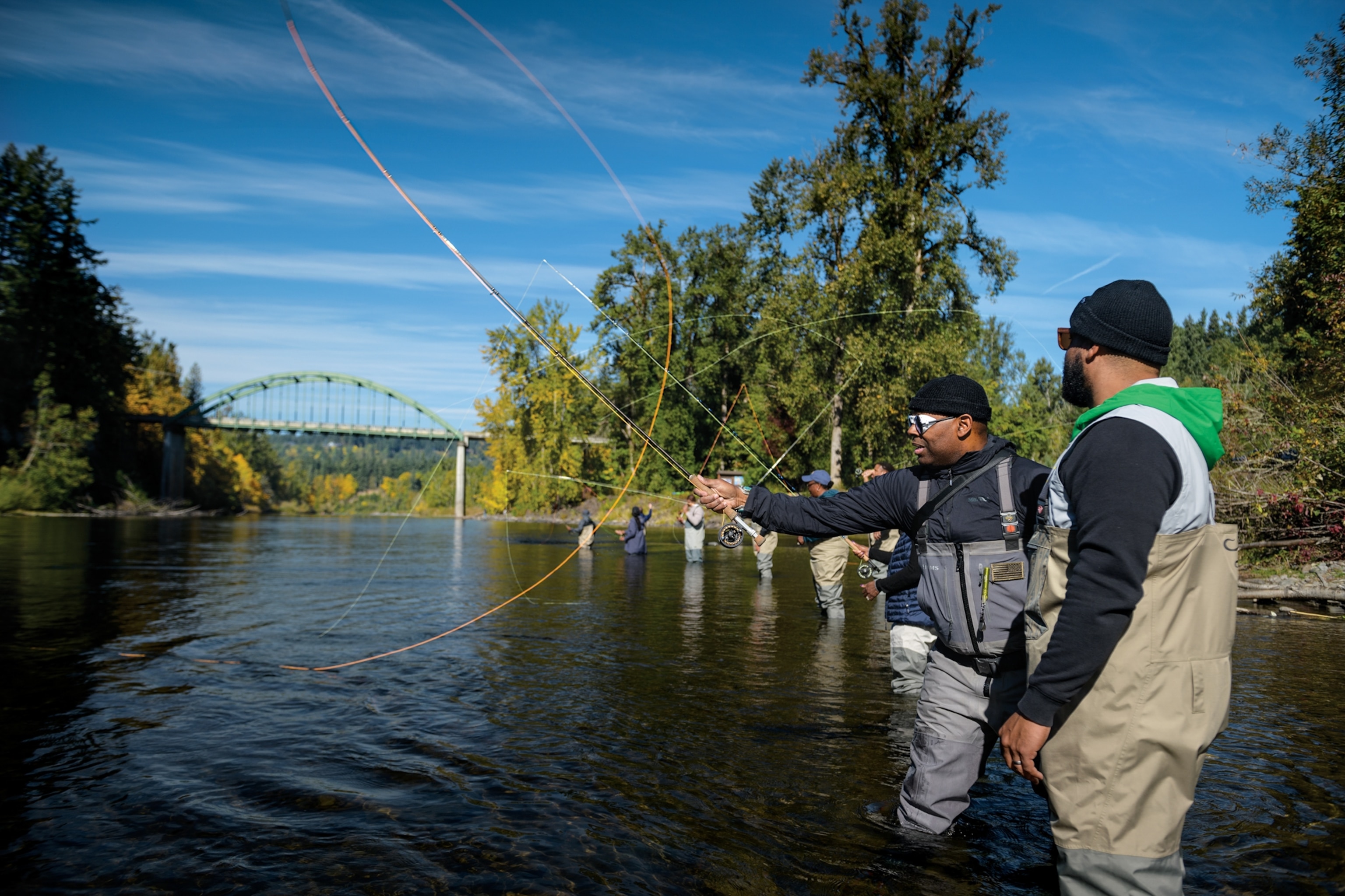 Picture of Chad Brown demonstrating a fly fishing cast for Stephen Green.