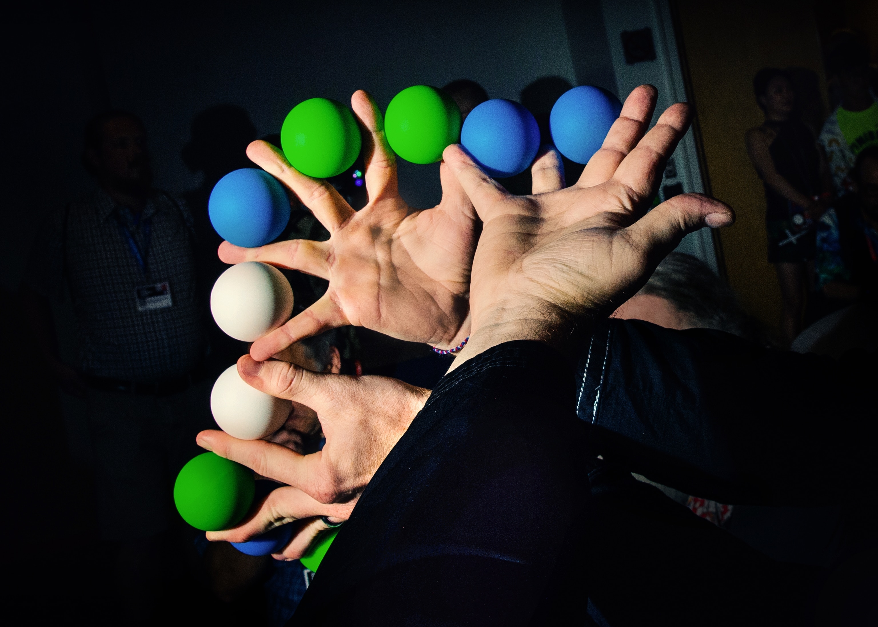 Magicians hands holding balls between each of their fingers