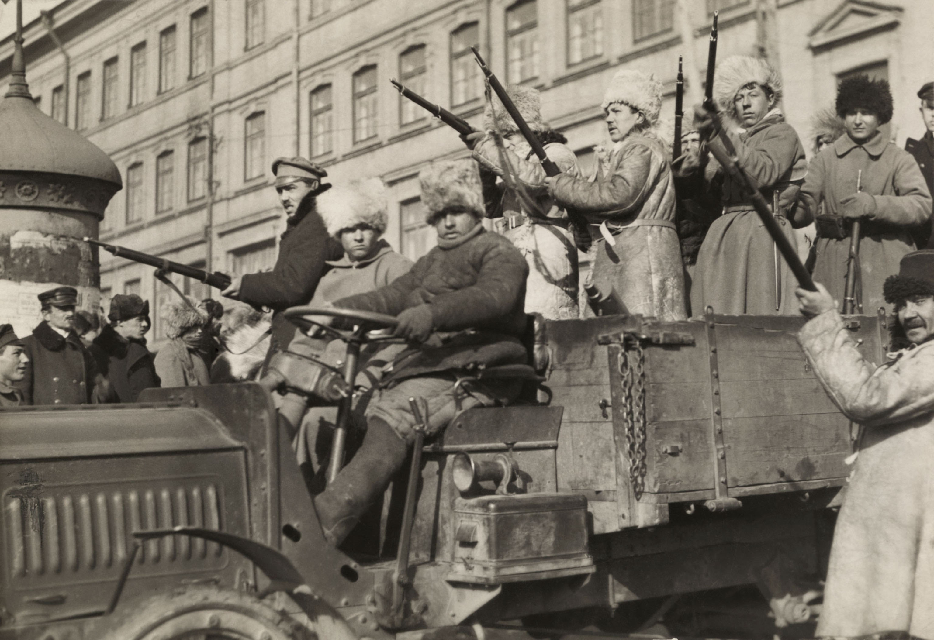Men with rifles ride in a pick up truck