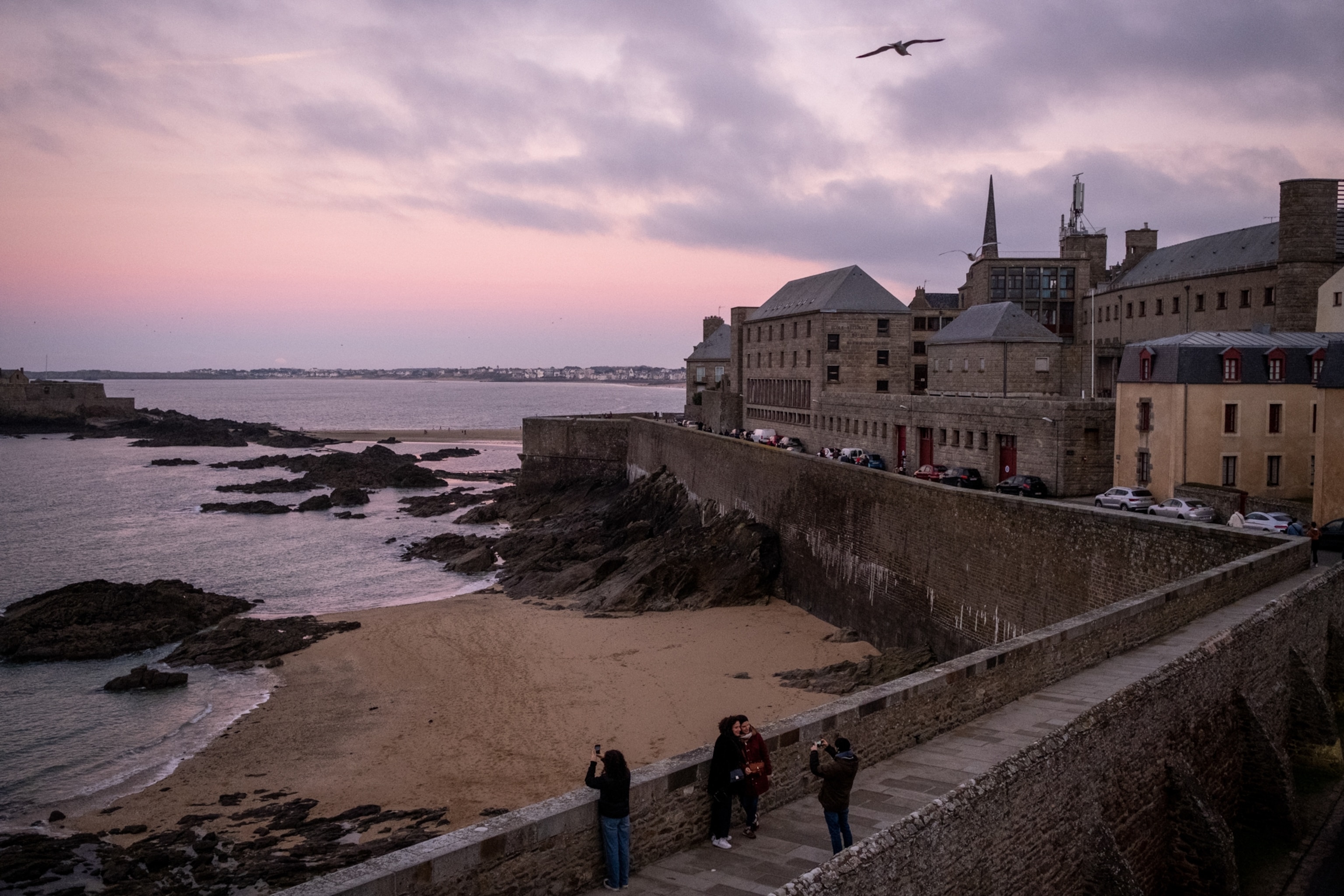 People taking in the scenery as they walk the ramparts of St. Malo.