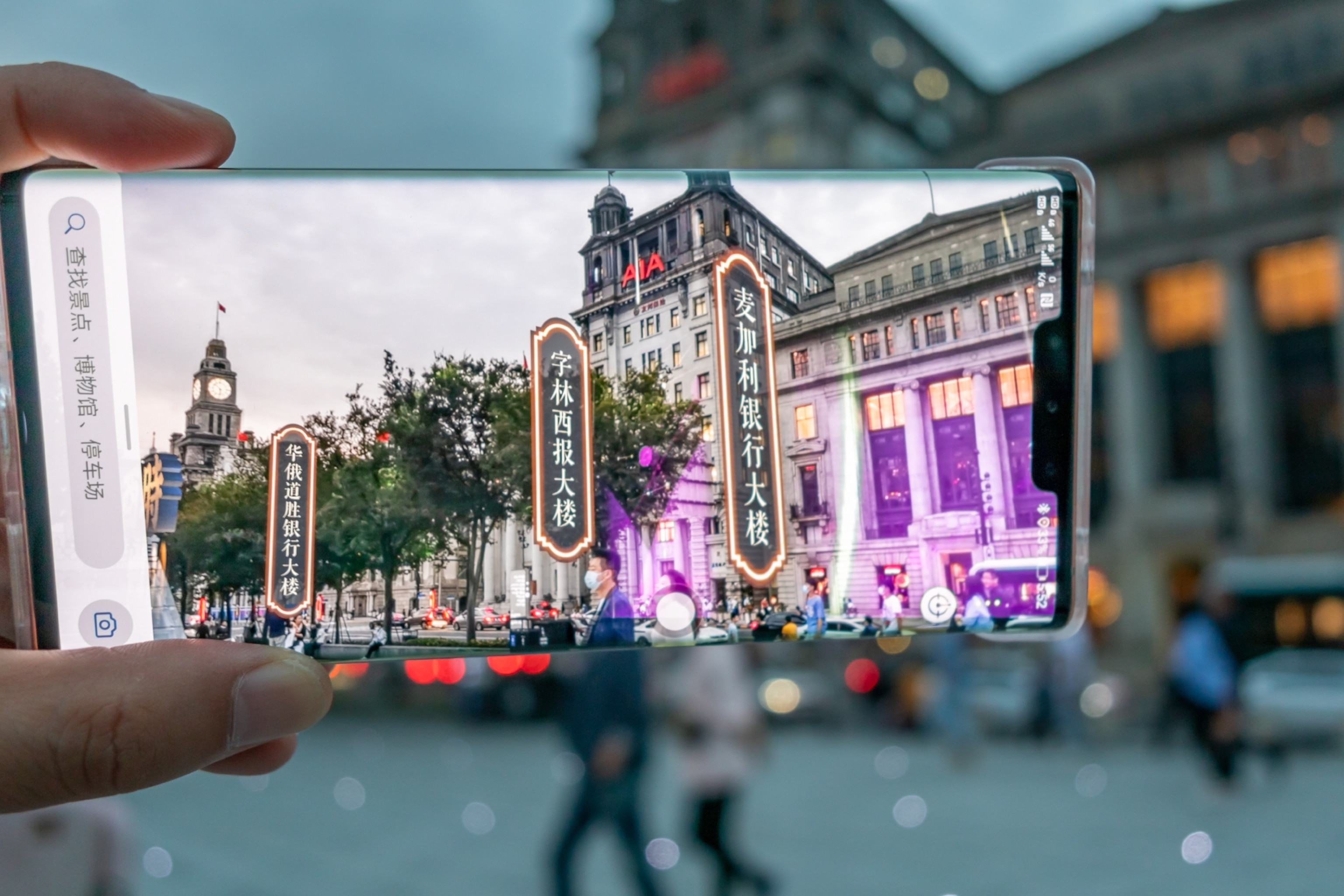 A mobile phone shows a street scene enhanced with digital street signs