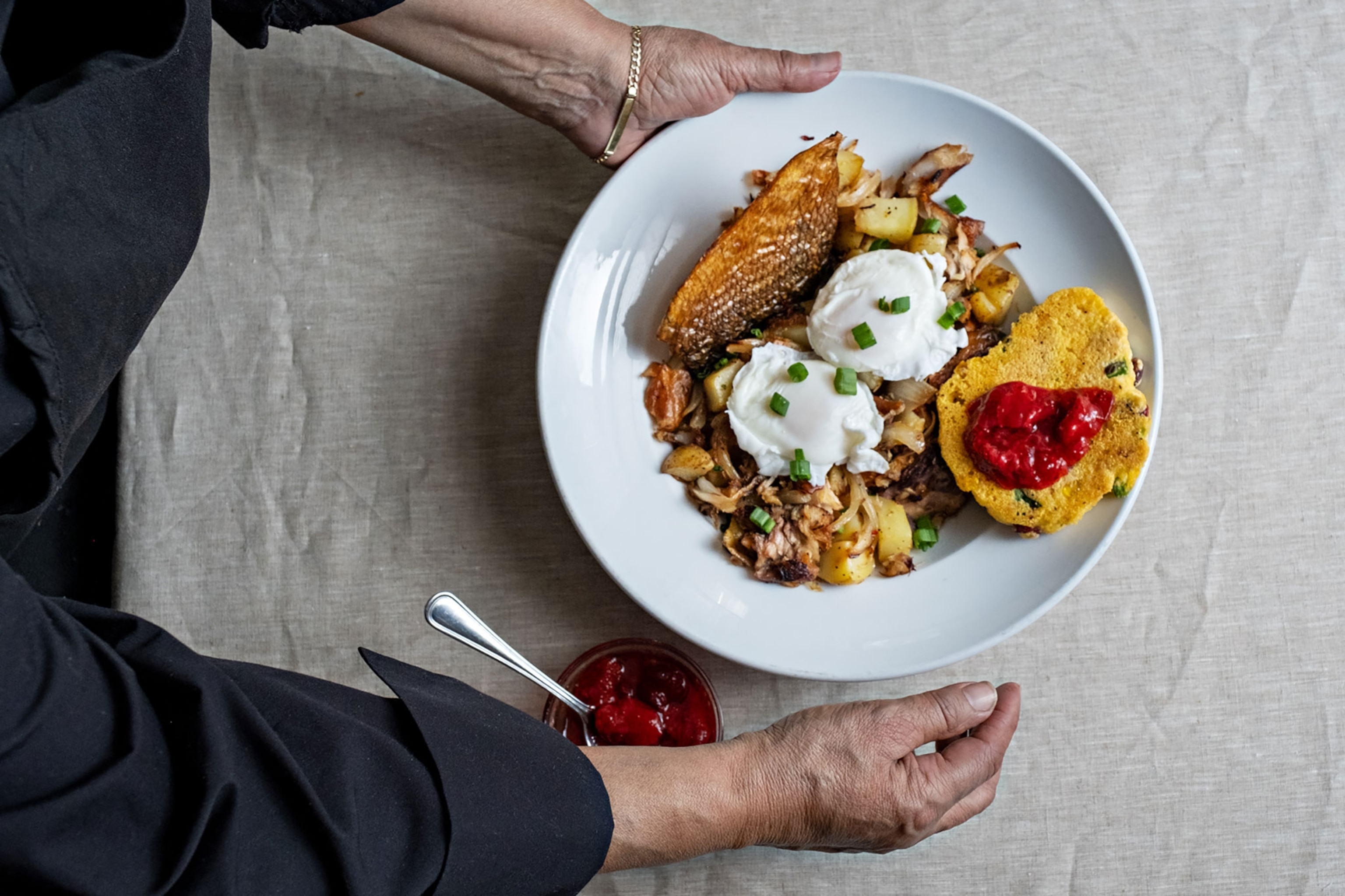 Hands holding plate full of food.