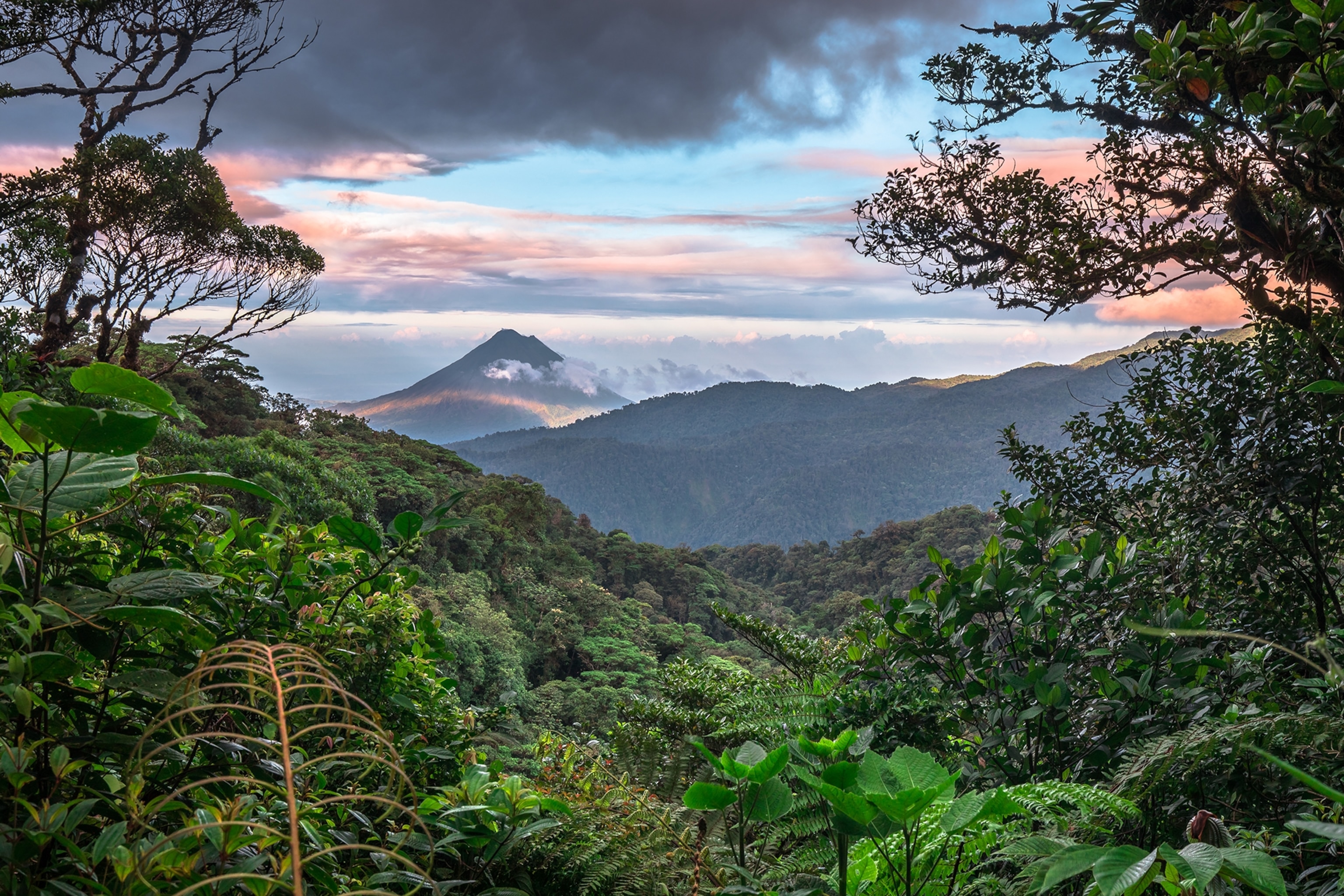 Volcan Arenal dominates the landscape during sunset, as seen from the Monteverde area, Costa Rica.