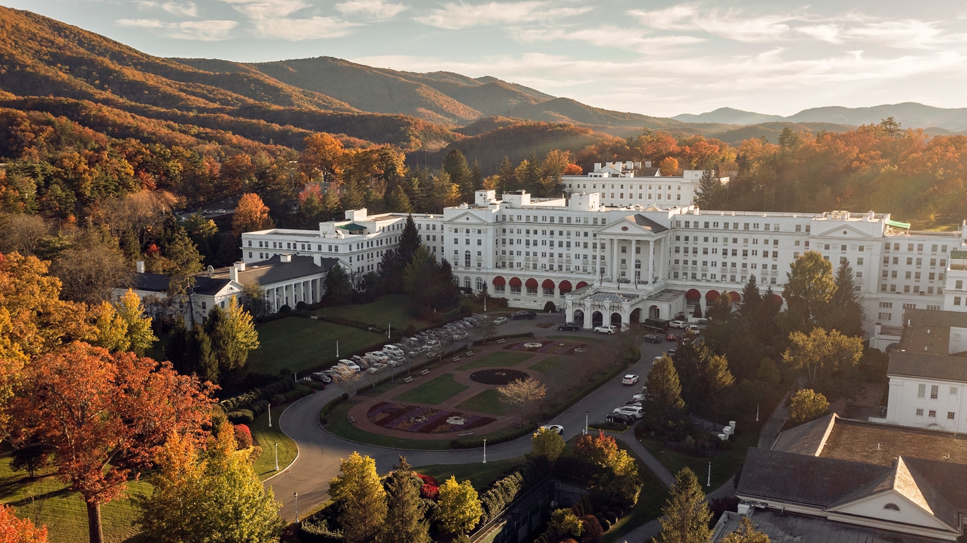 Aerial of the front entrance of The Greenbrier Hotel surrounded by a forest.
