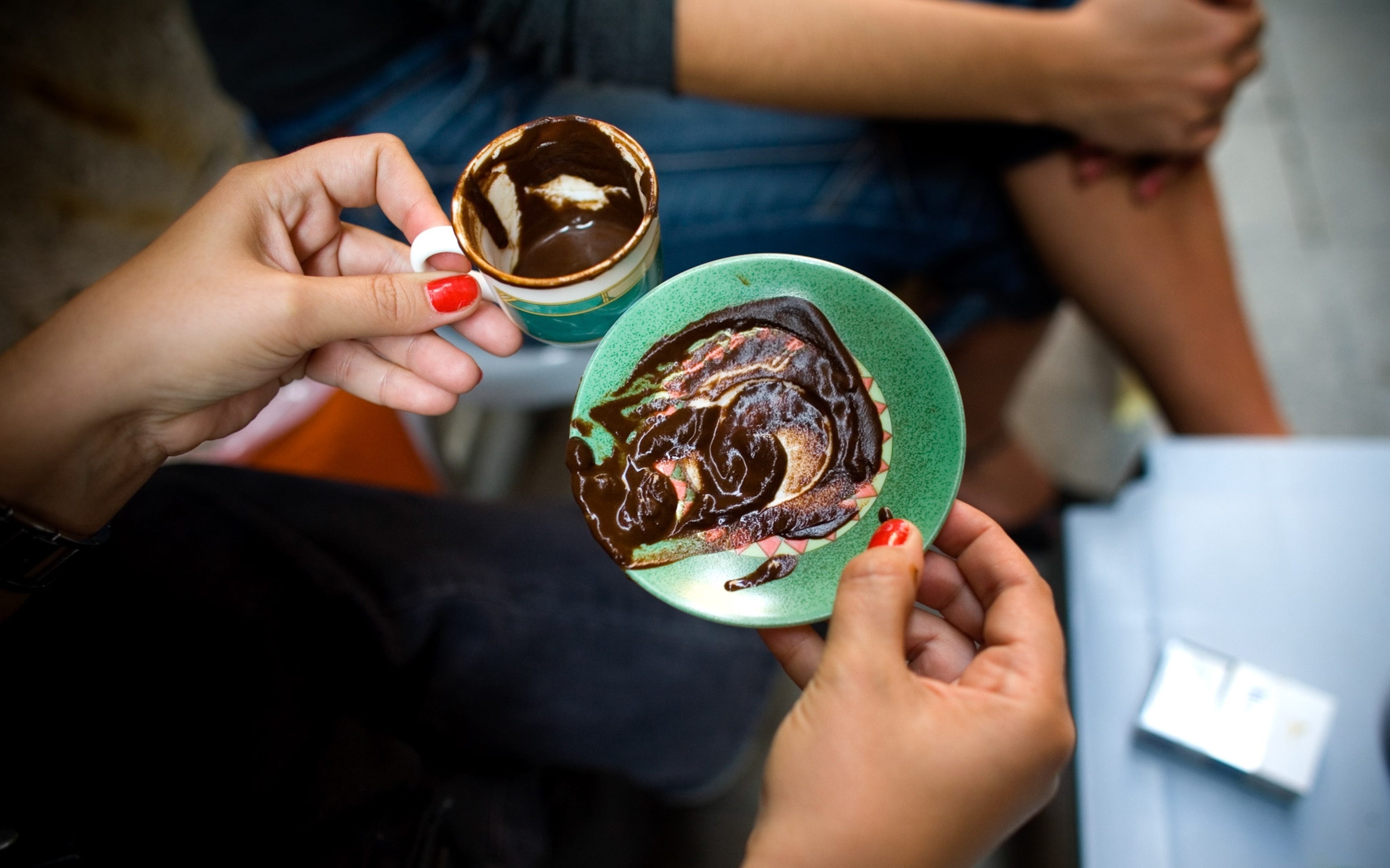 Thick ground coffee is smeared on a plate and in a cup.