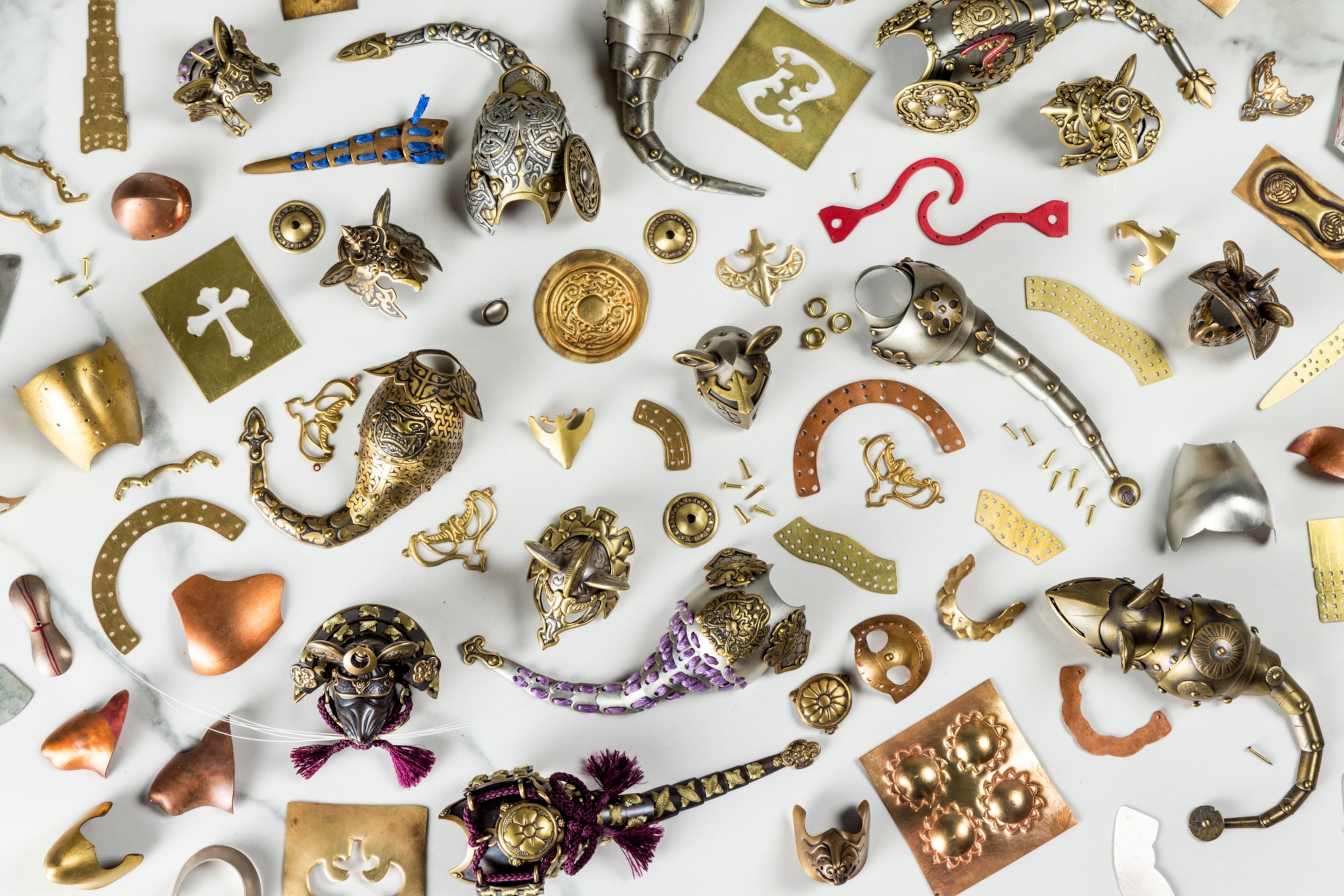 Pieces of metal used to make cat and mouse armor on a white background