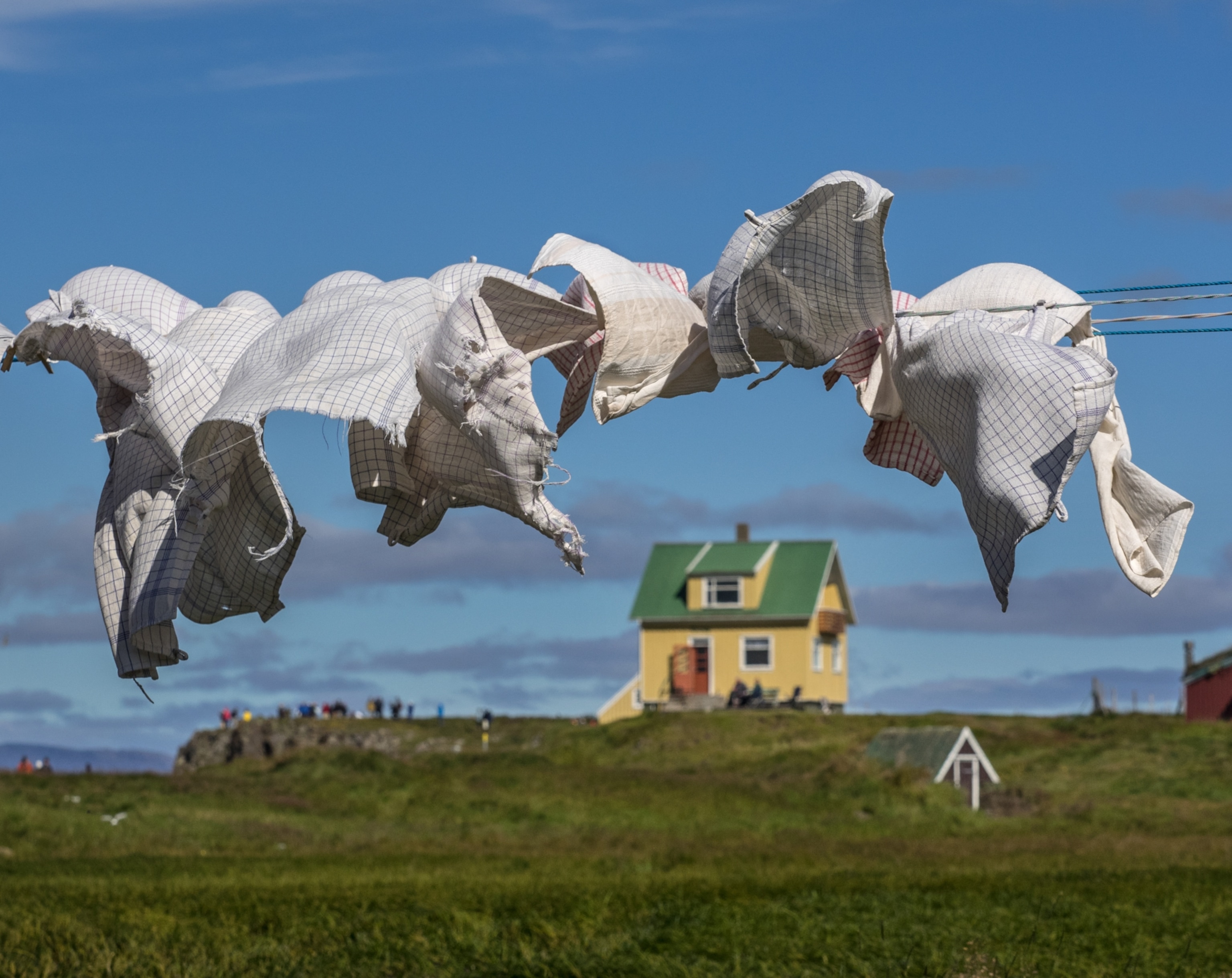 Clothes are blowing in the wind as they hang dry.