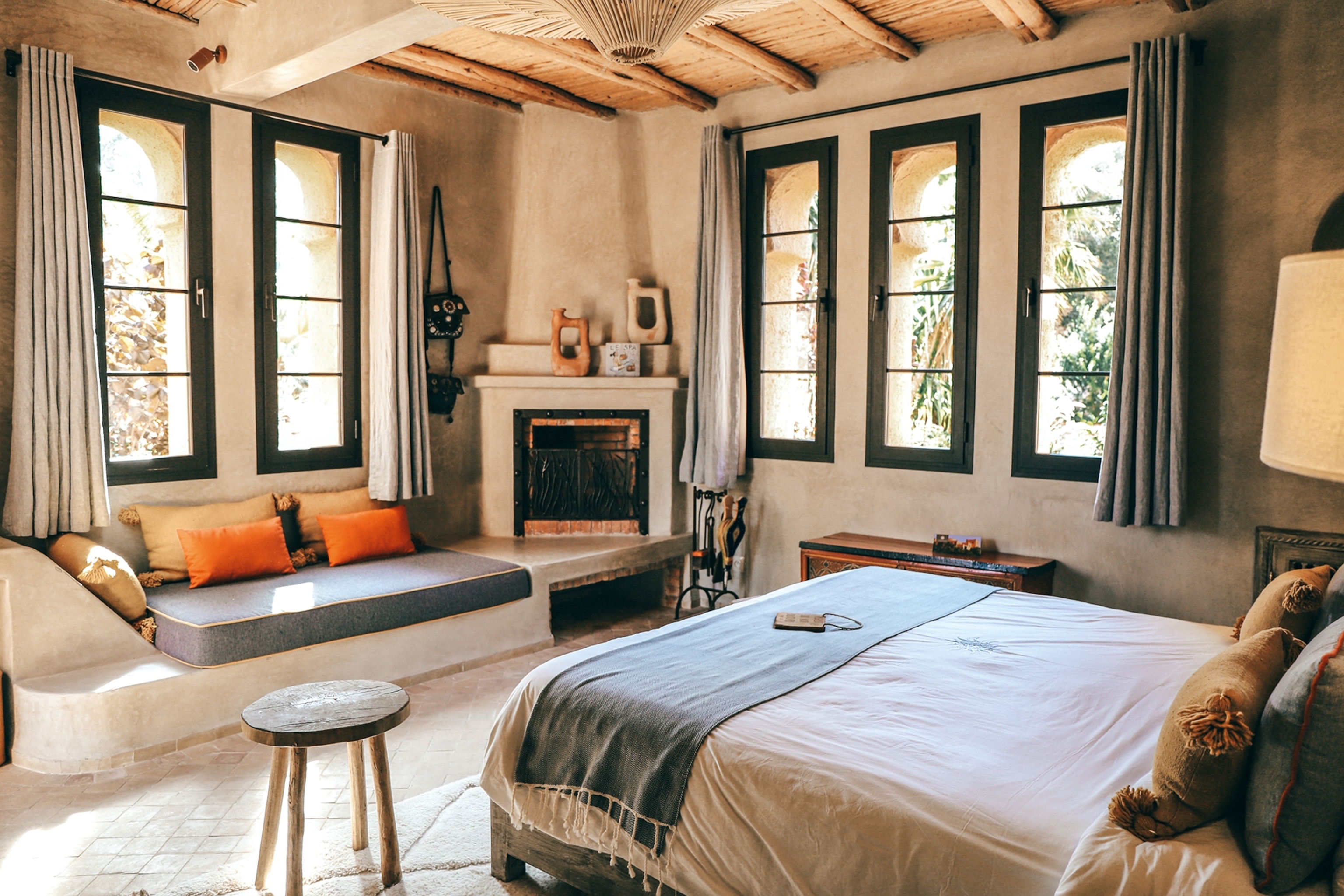 View inside a hotel room with multiple long rectangular windows, a window rest and fireplace.