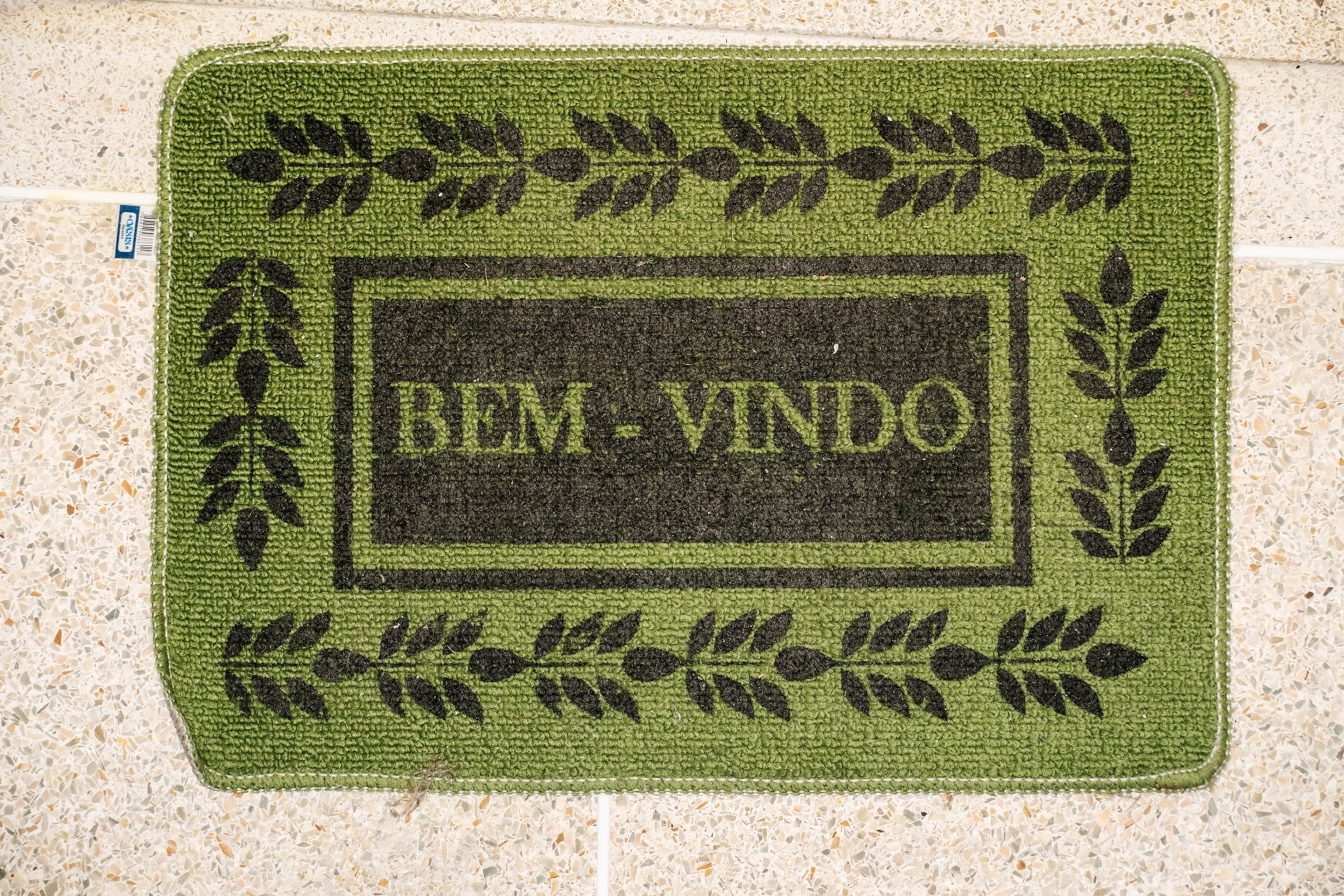 an green home entrance mat that says "bem-vindo"