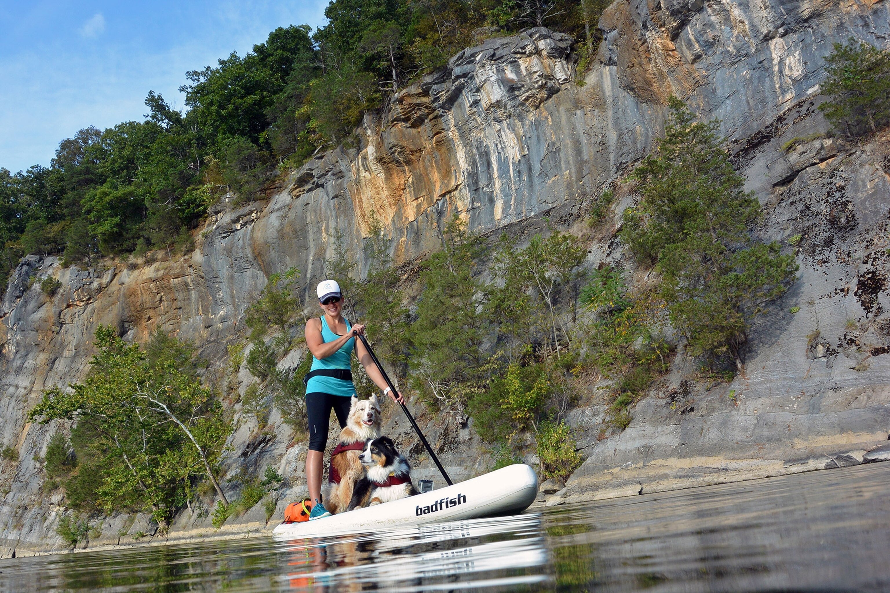 a woman stand-up paddle boarding with her dog in the Shenandoah river, Virginia