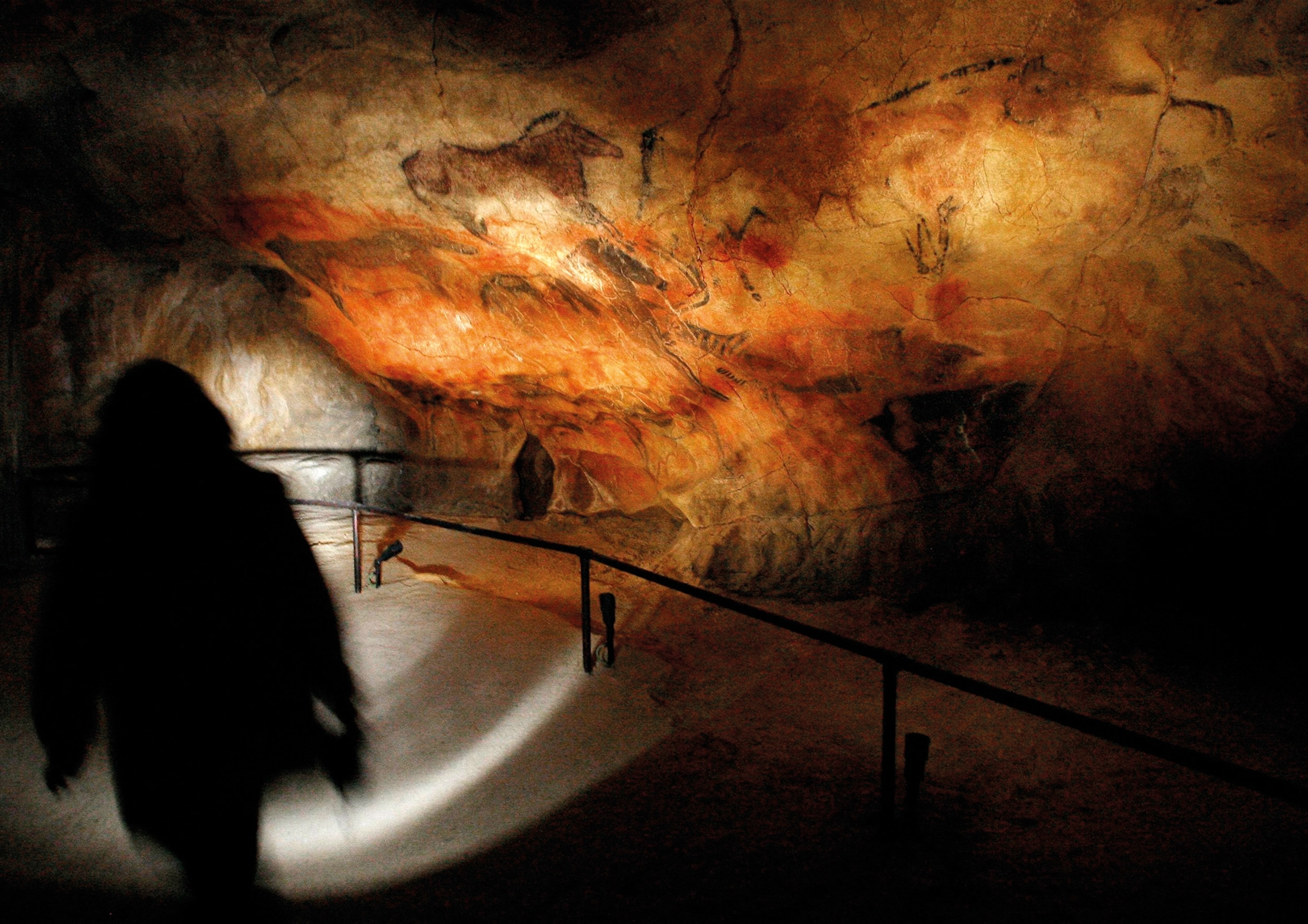 Visitors view the main panel at Tito Bustillo, which features almost 100 representations of animals.