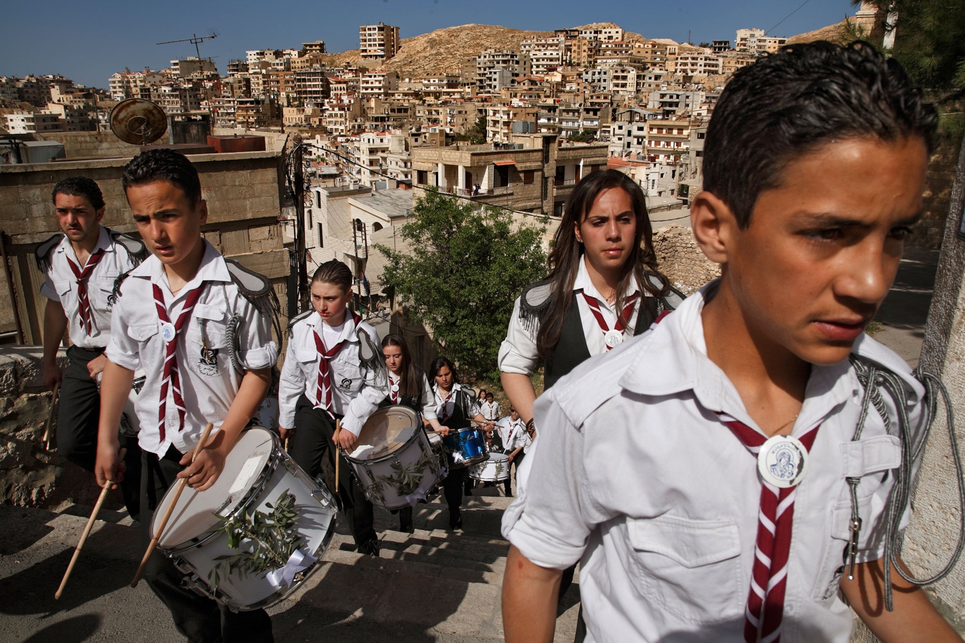 drummers walking up a hill in a city
